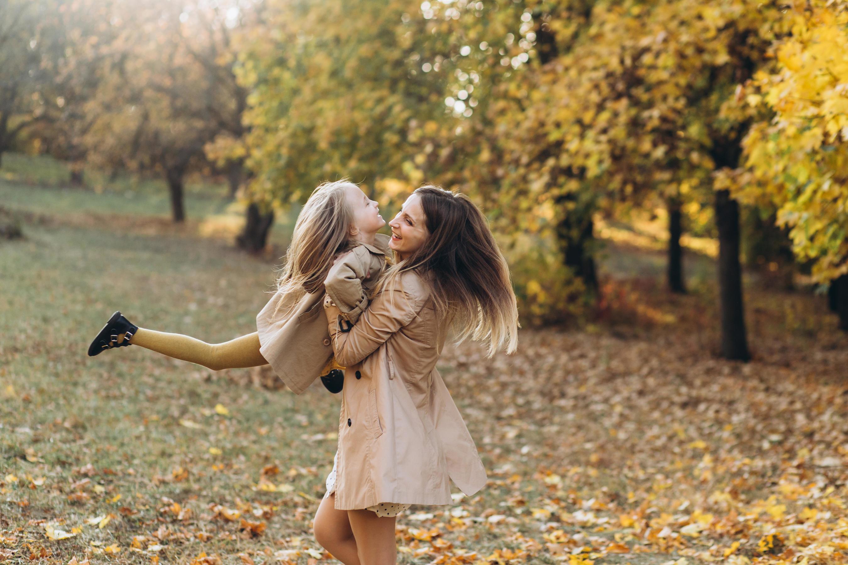 Mother and her daughter have fun and walk in the autumn park. Stock Free