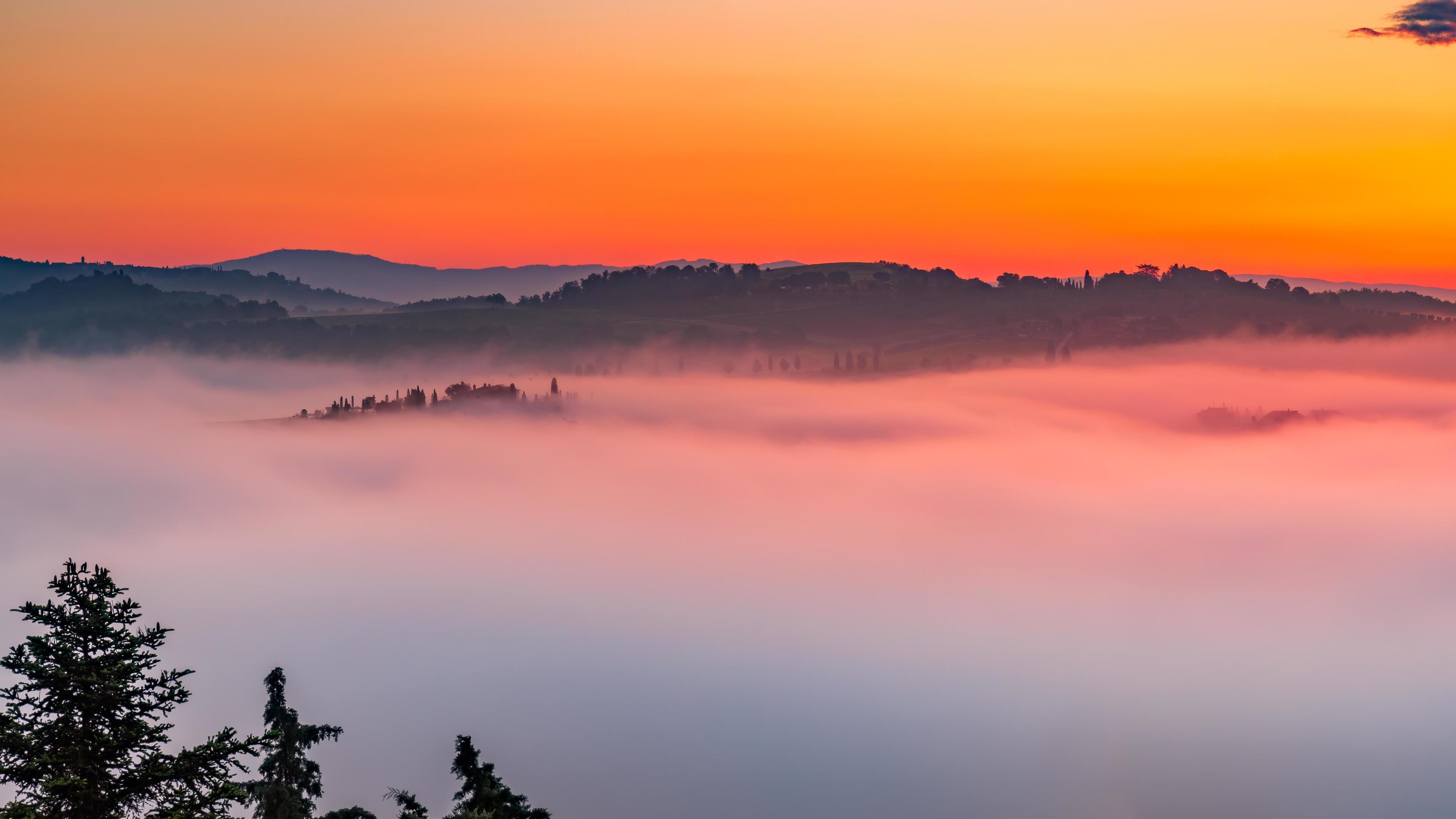 Early morning mist flooding the valleys of Tuscany at sunrise Stock Free