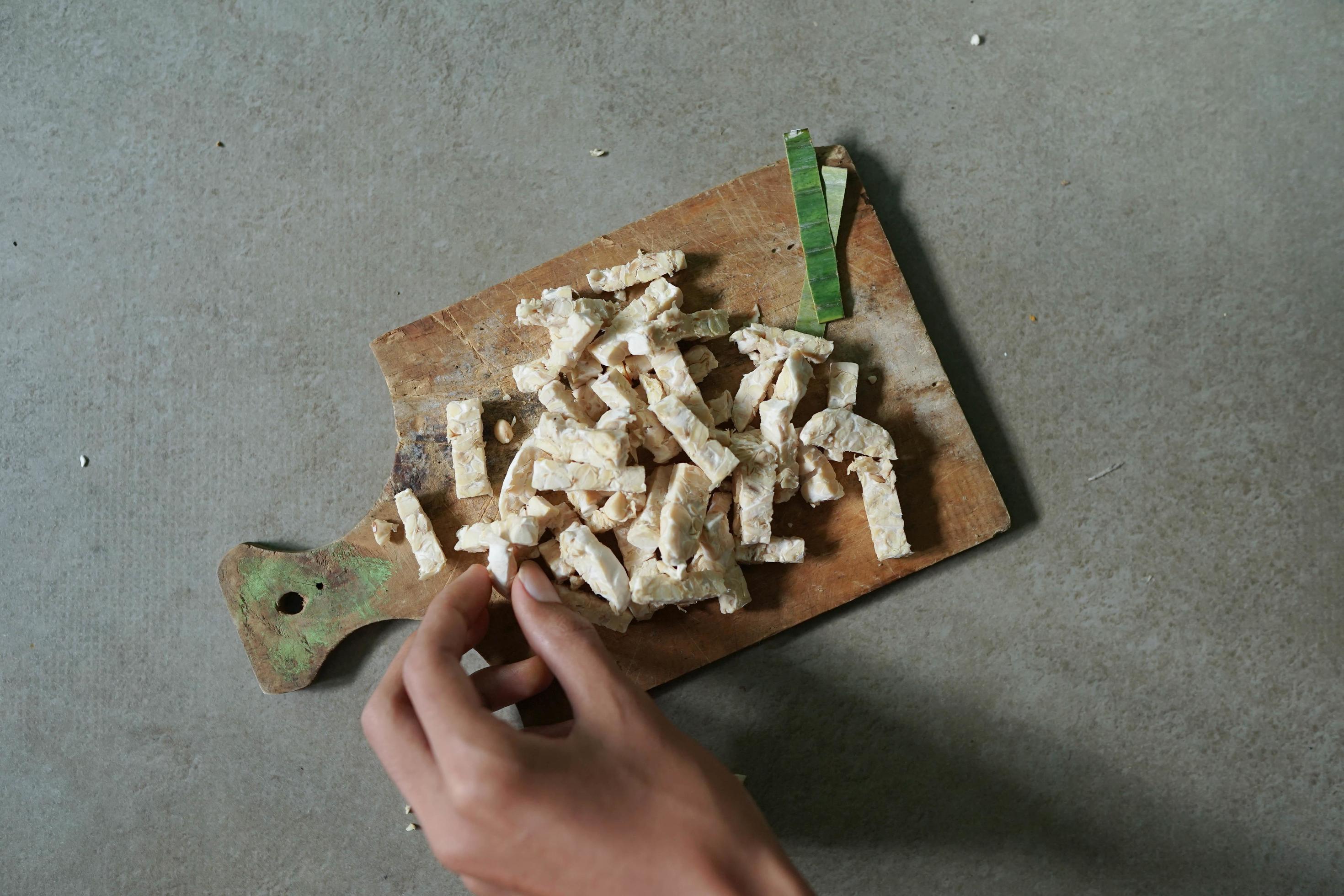 Indonesian food raw tempeh sliced into squares on a concrete background Stock Free