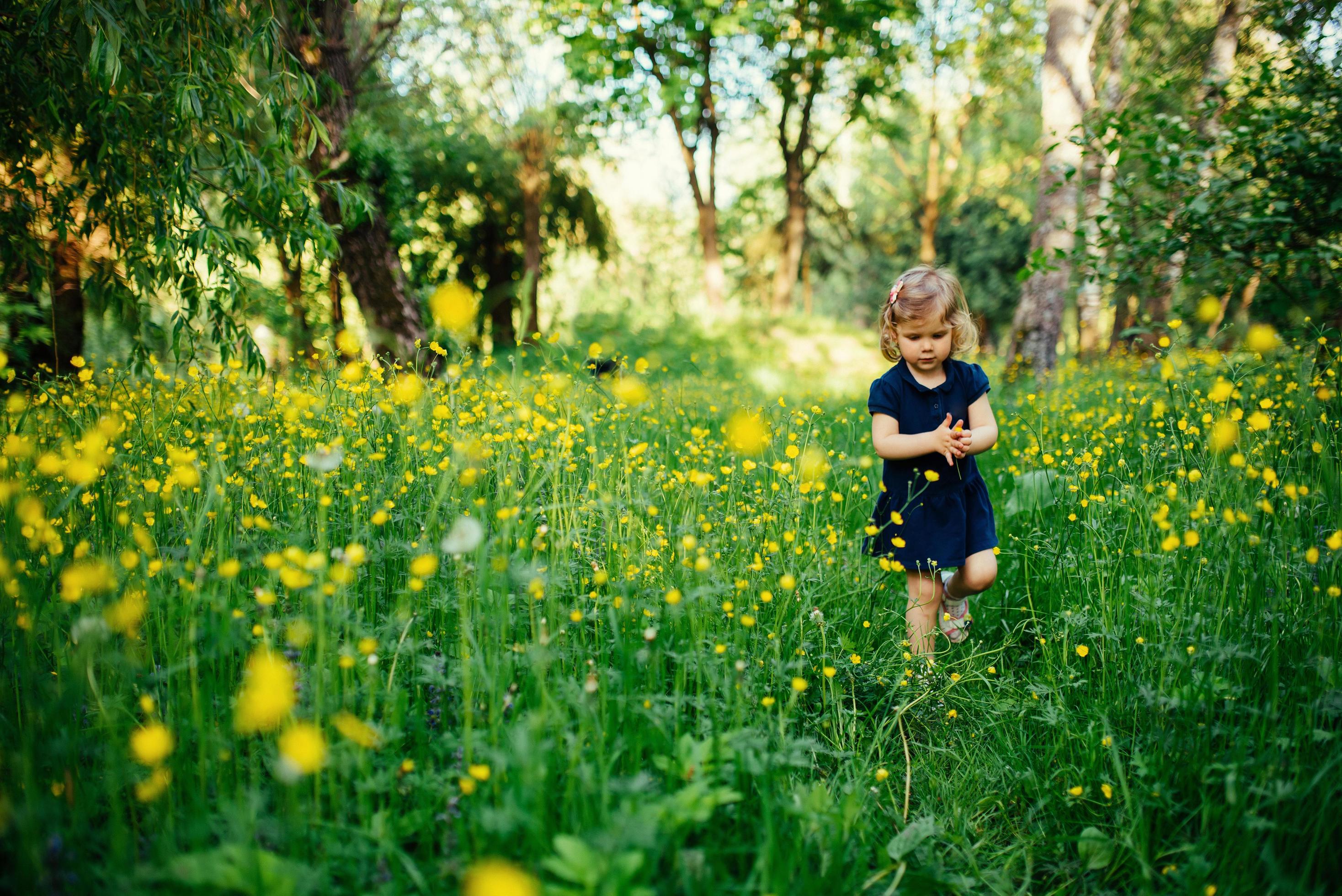 child playing outdoors in the grass Stock Free