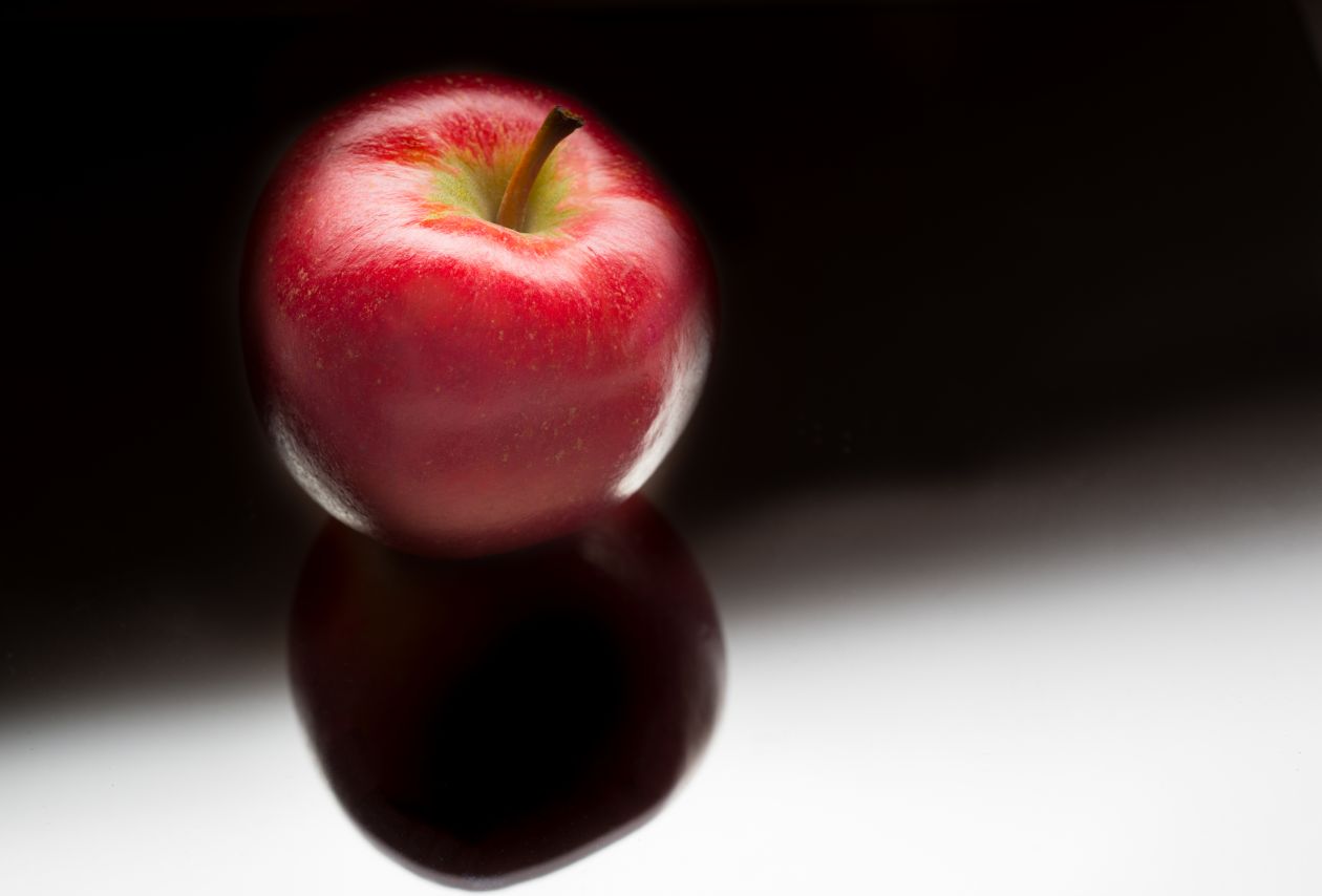 Shiny apple on black background Stock Free