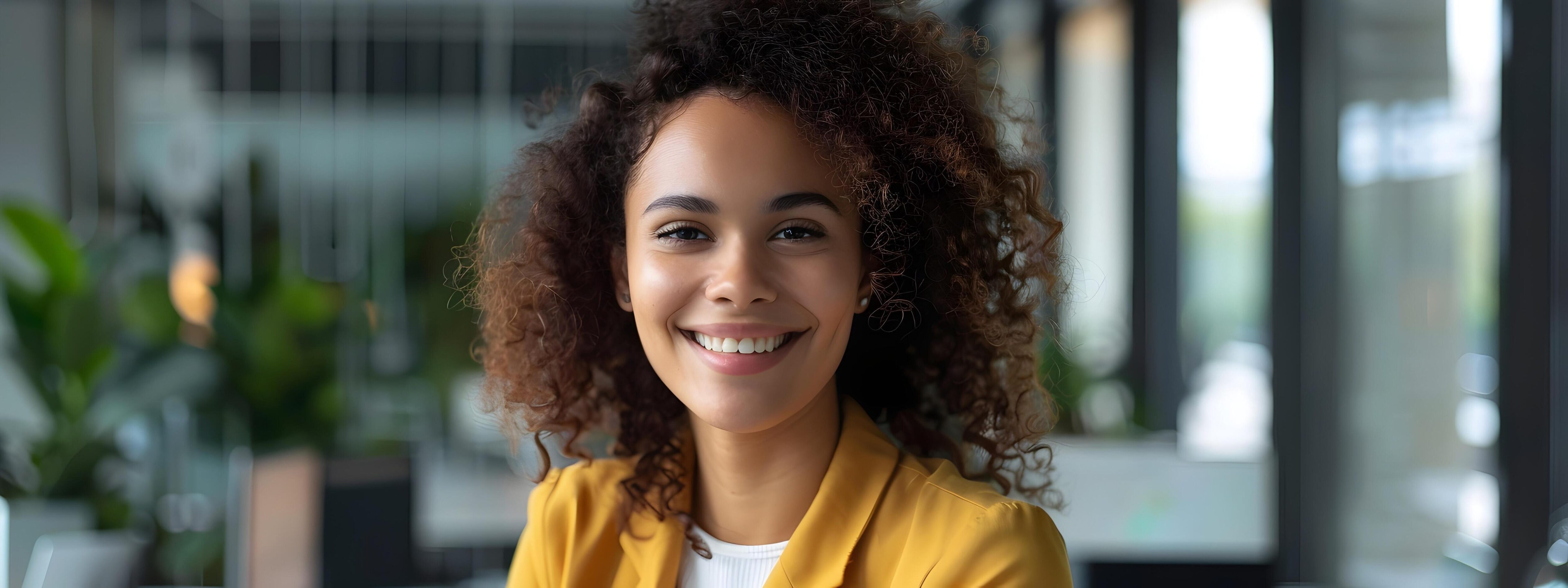 Confident Young Professional Woman Smiling at Laptop in Office Setting Stock Free