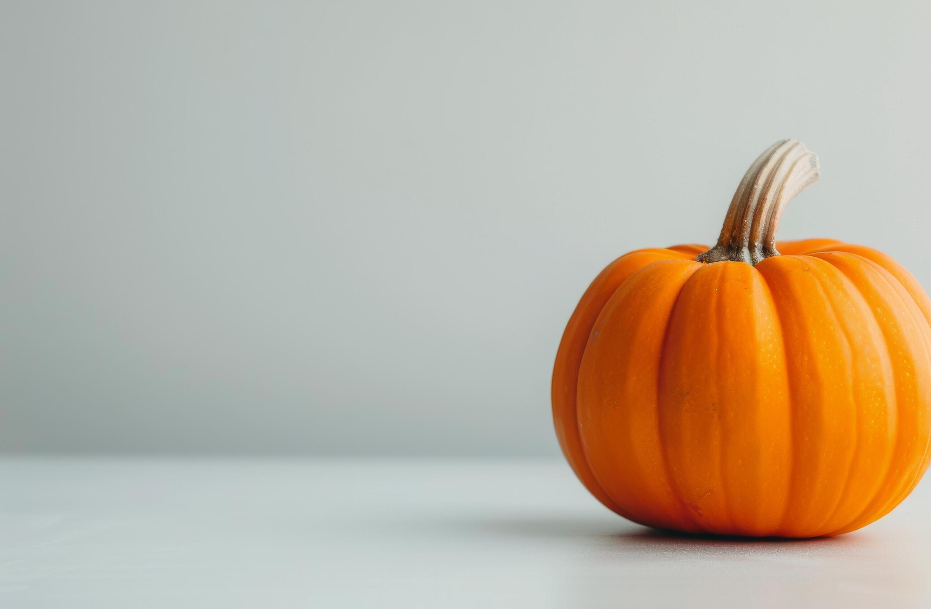 Vibrant Orange Pumpkin With Autumn Leaves on Warm Background Stock Free