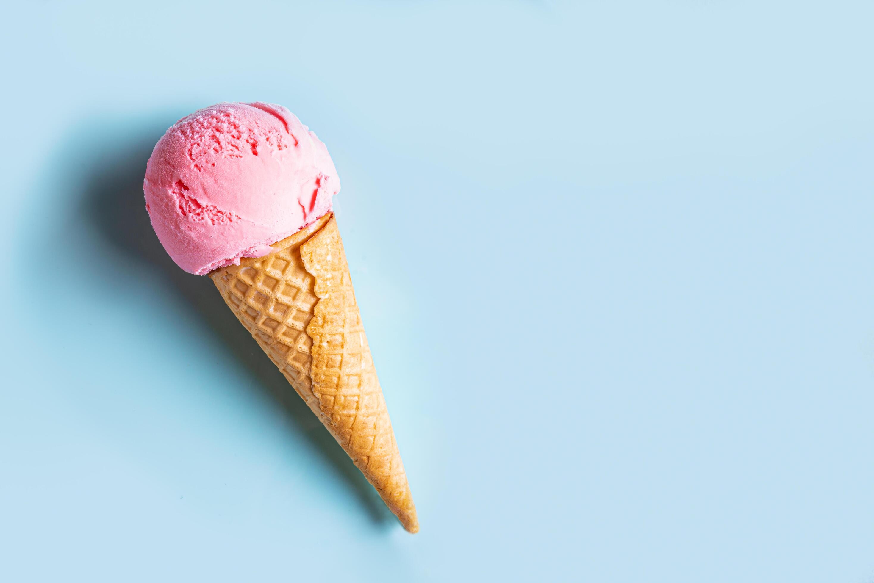 Pink ice cream cone on blue background Stock Free