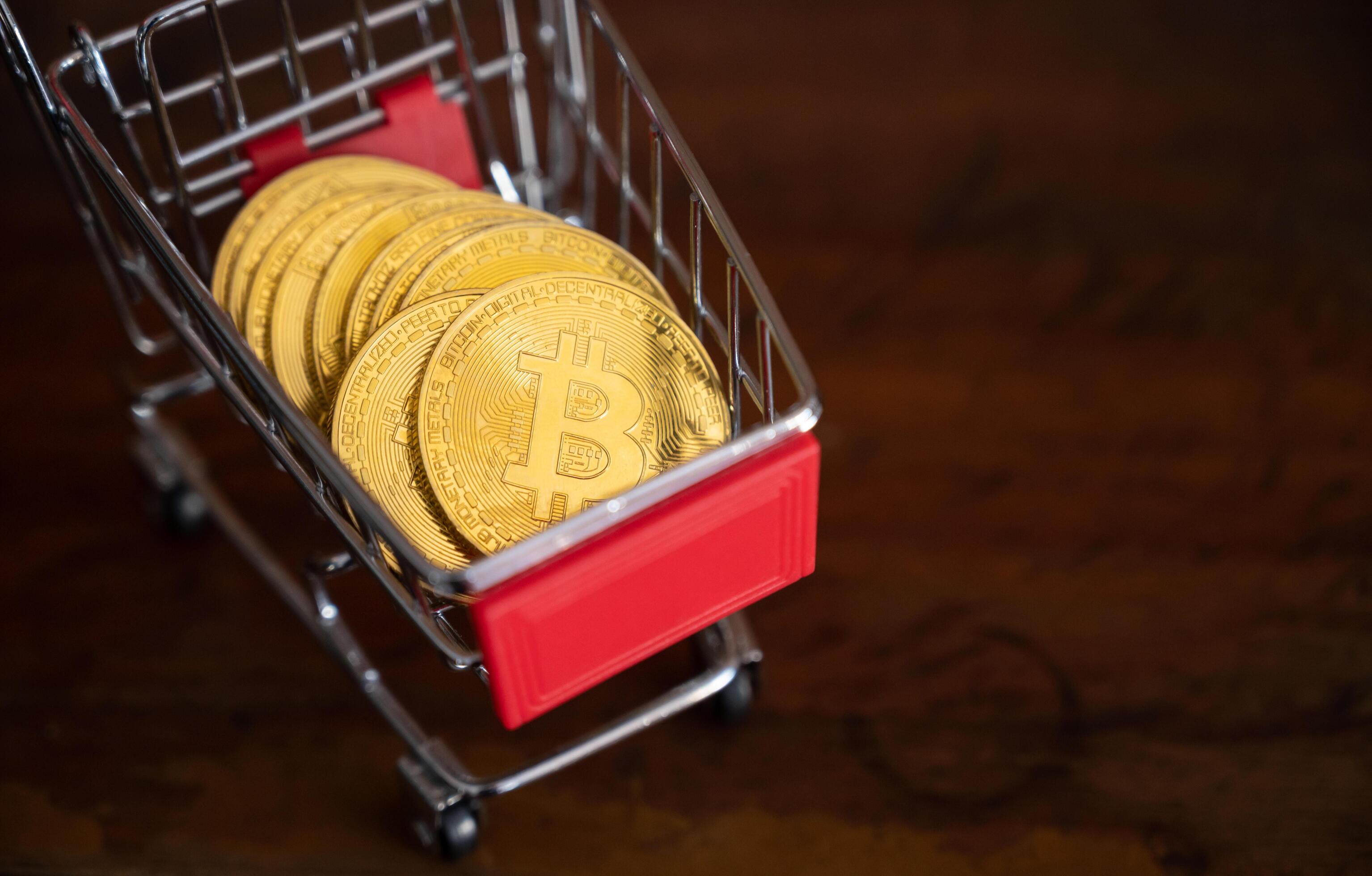 Bitcoin token in a trolley on wooden table. Bitcoin is one of the popular cryptocurrency, a virtual currency or a digital currency. Stock Free