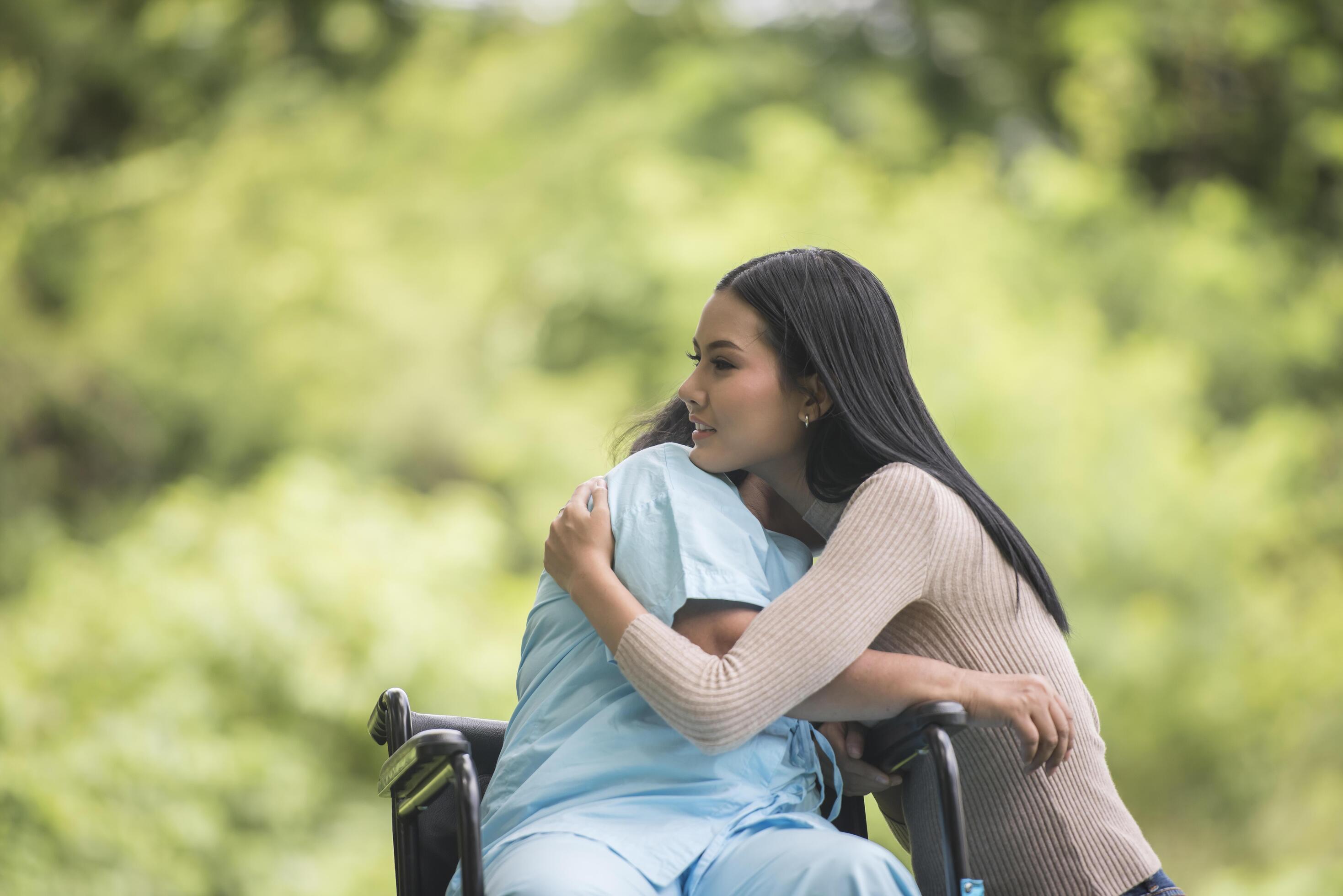 
									Granddaughter talking with her grandmother sitting on wheelchair, cheerful concept, happy family Stock Free