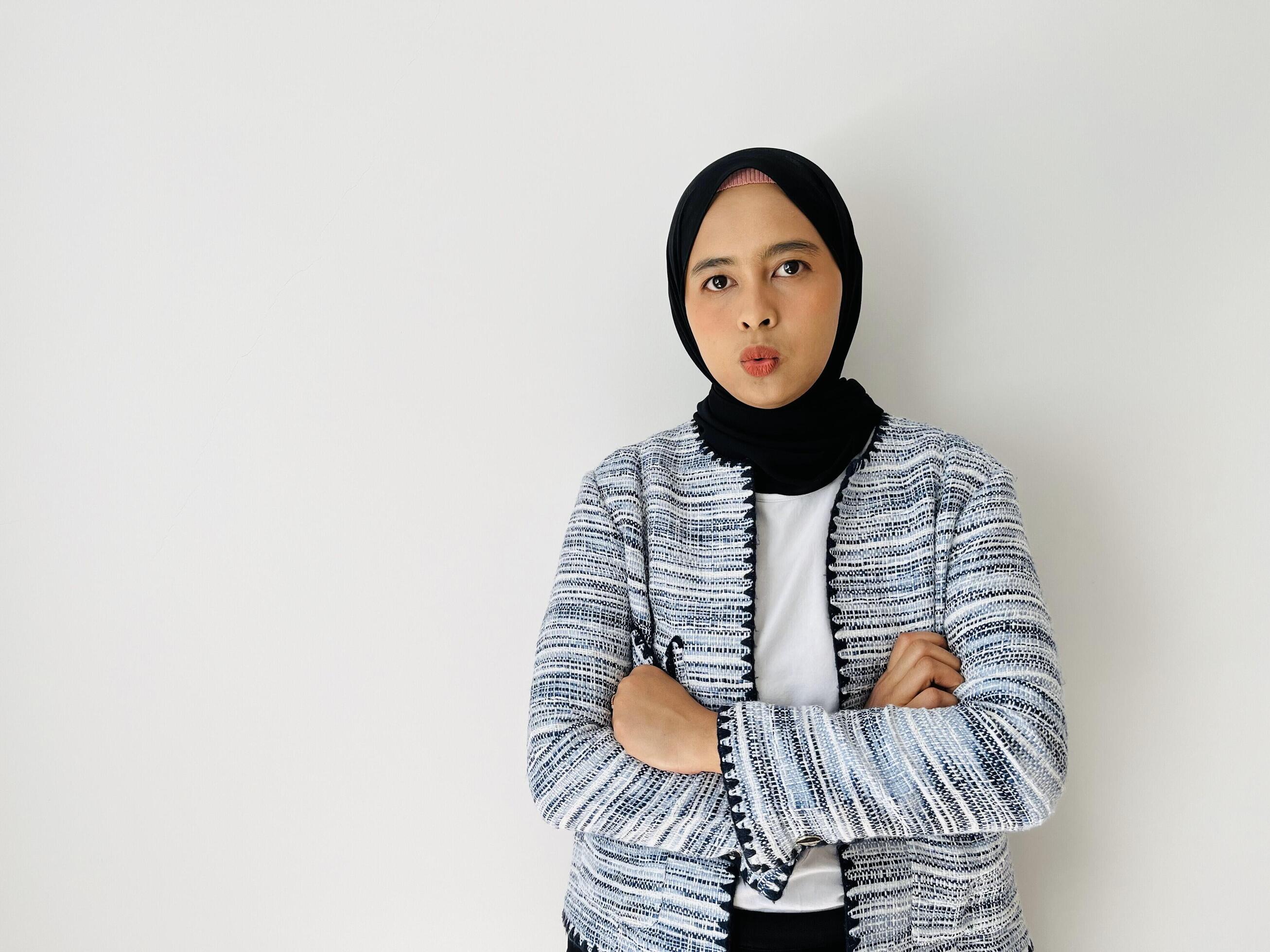 Seriously face young Asian Muslim woman crossed arms and looking confident isolated over white background Stock Free