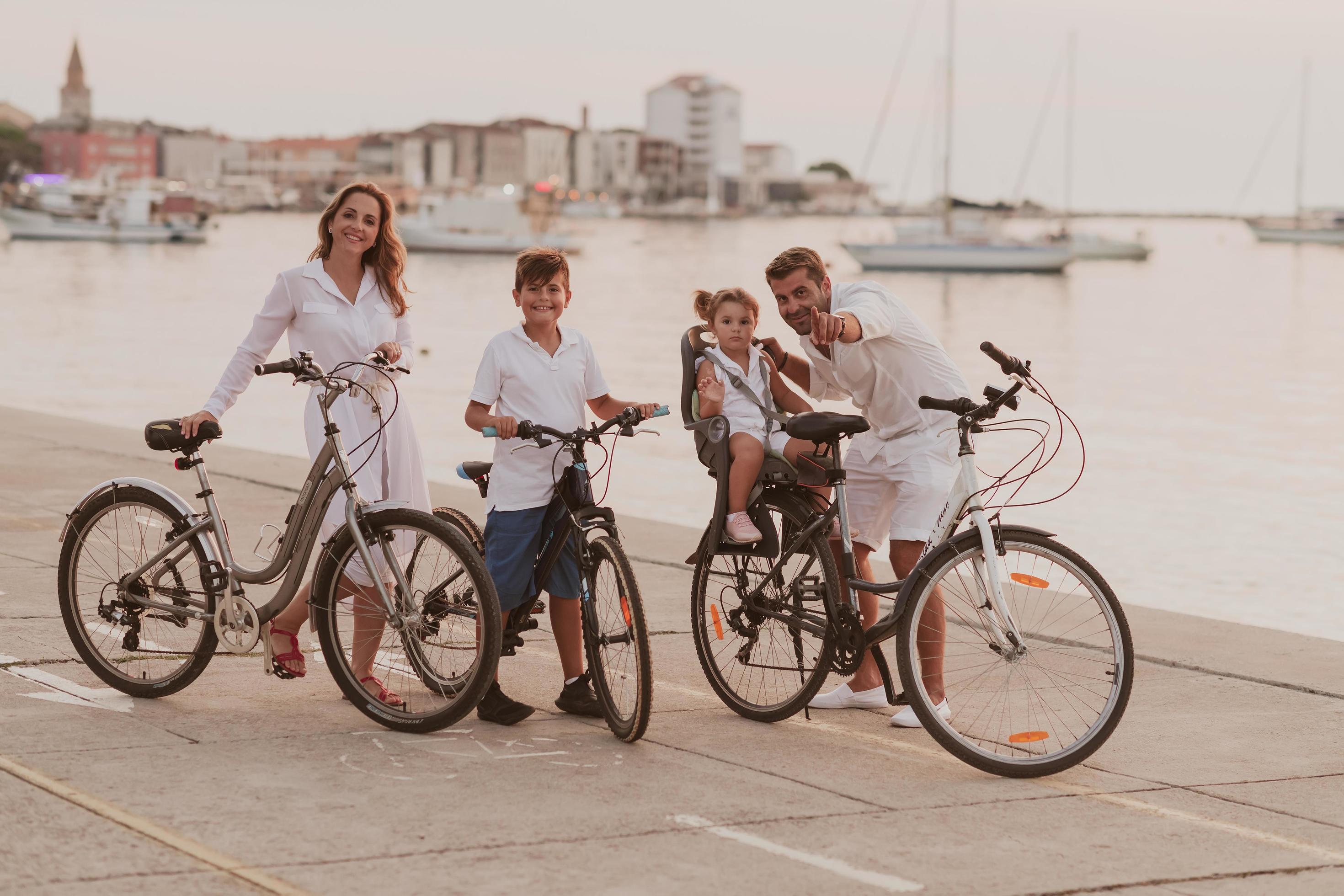 The happy family enjoys a beautiful morning by the sea riding a bike together and spending time together. The concept of a happy family Stock Free