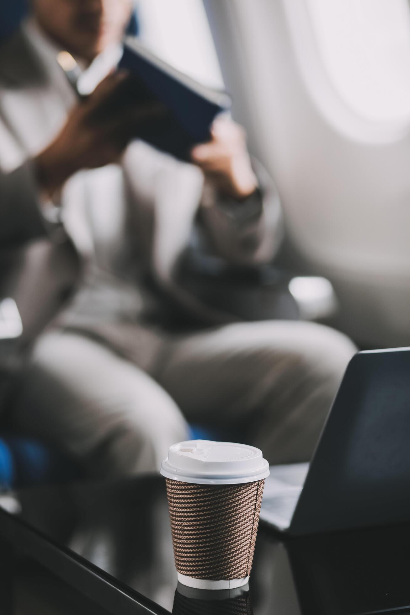 Asian businessman enjoying enjoys a coffee comfortable flight while sitting in the airplane cabin, Passengers near the window. Stock Free