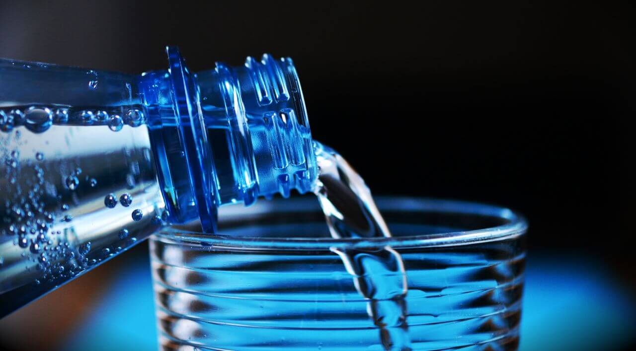 Bottle Pouring Water on Glass Stock Free