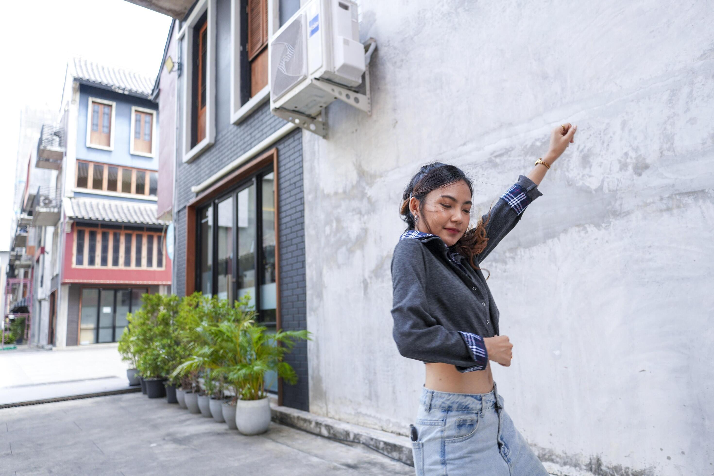 Asian women do freestyle hip hop and breakdancing in a public space in the middle of the city. With a cheerful and happy attitude Stock Free