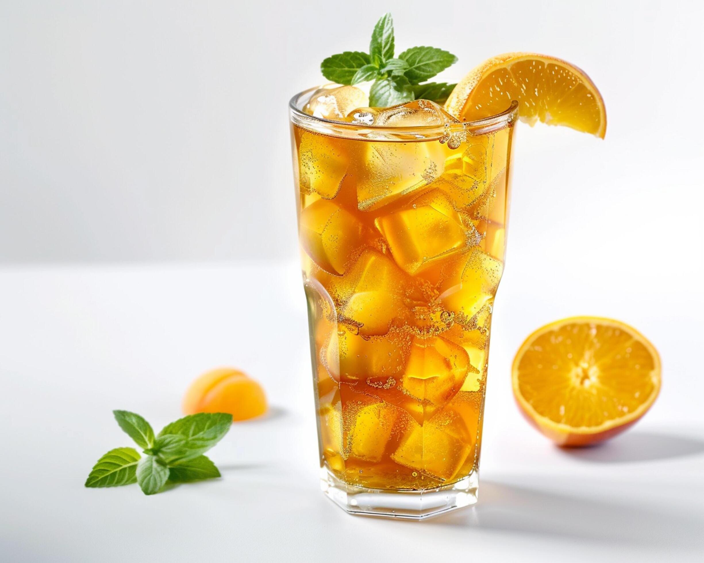 an orange iced tea with mint leaves and ice cubes Stock Free