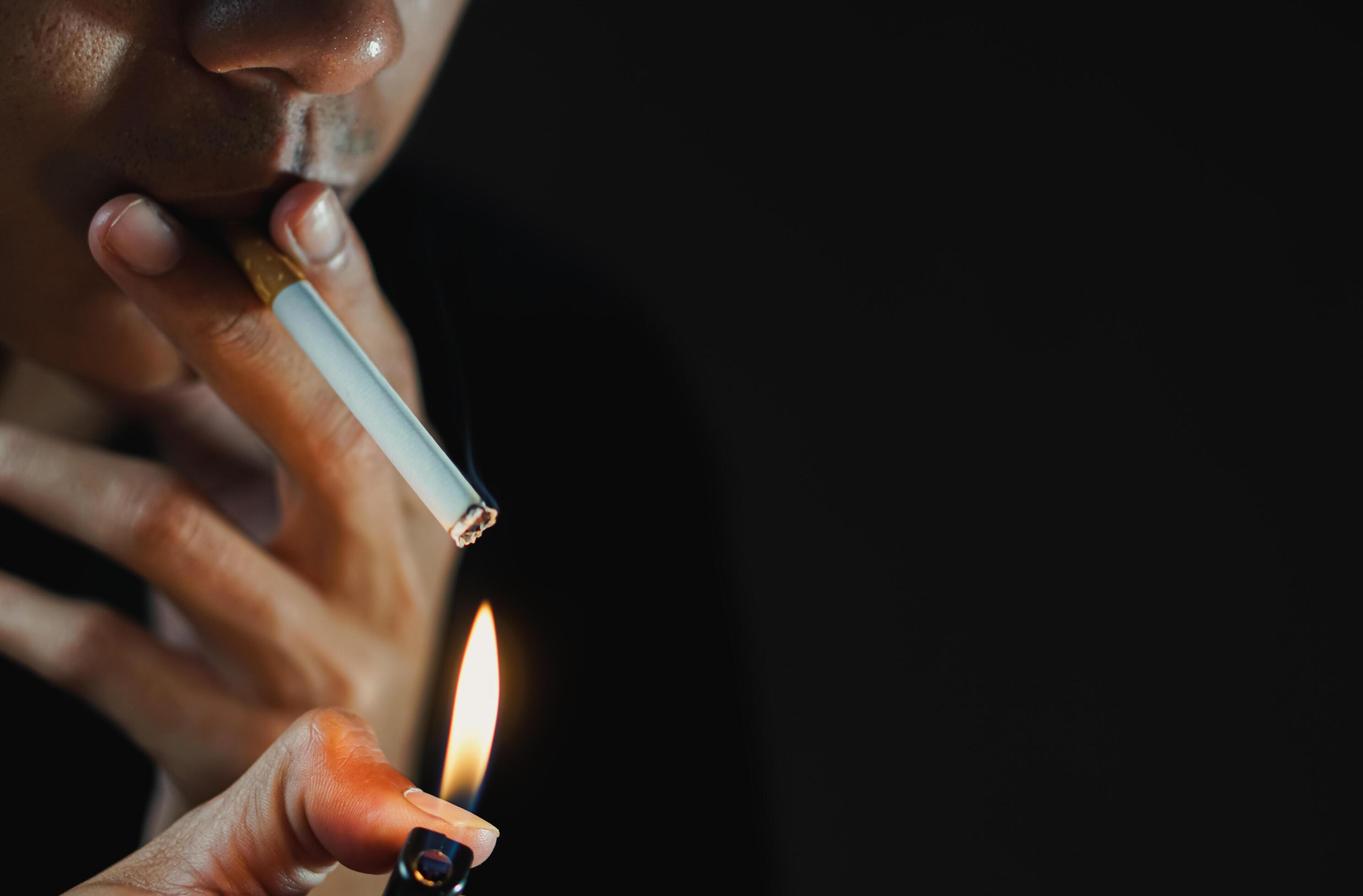 A man smoking cigarette in dark room Stock Free