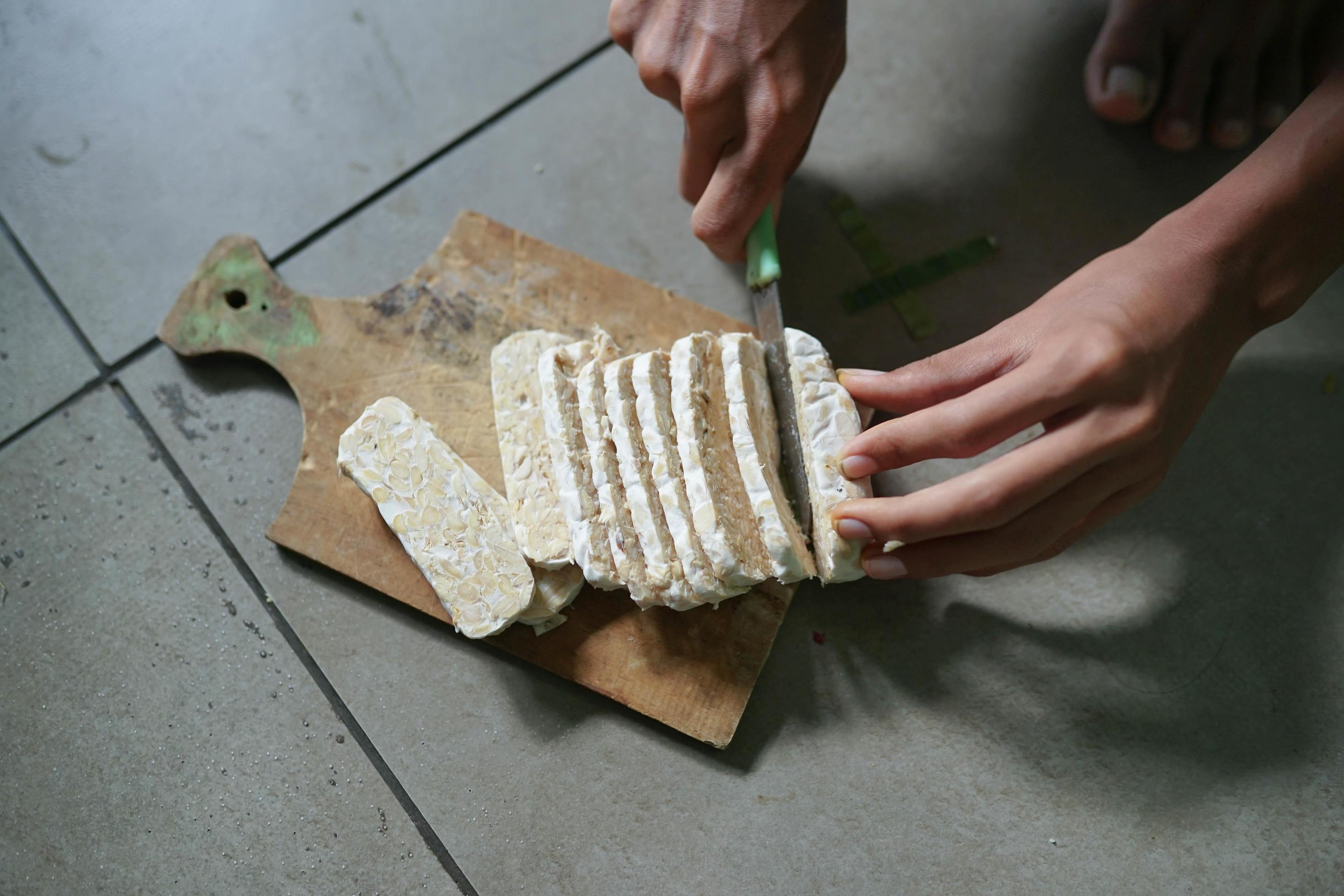 Indonesian food, raw tempeh sliced on a concrete background Stock Free