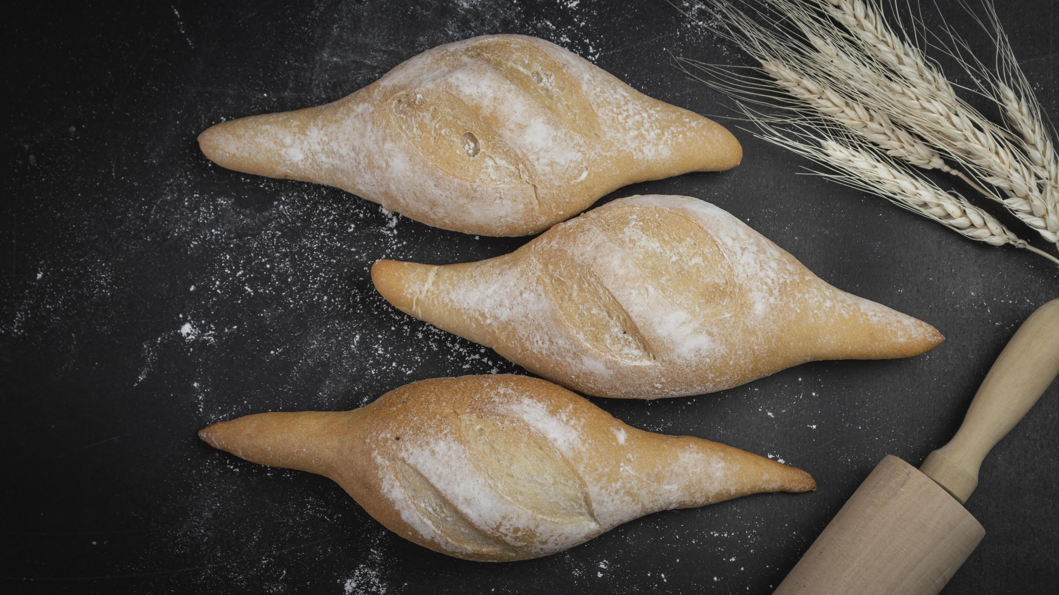 three buns with flour and wheat on a black background Stock Free