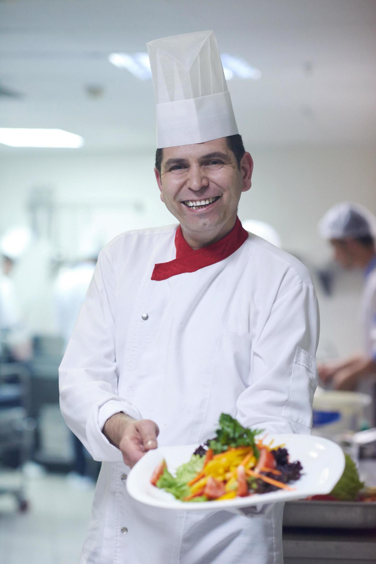 chef in hotel kitchen preparing and decorating food Stock Free