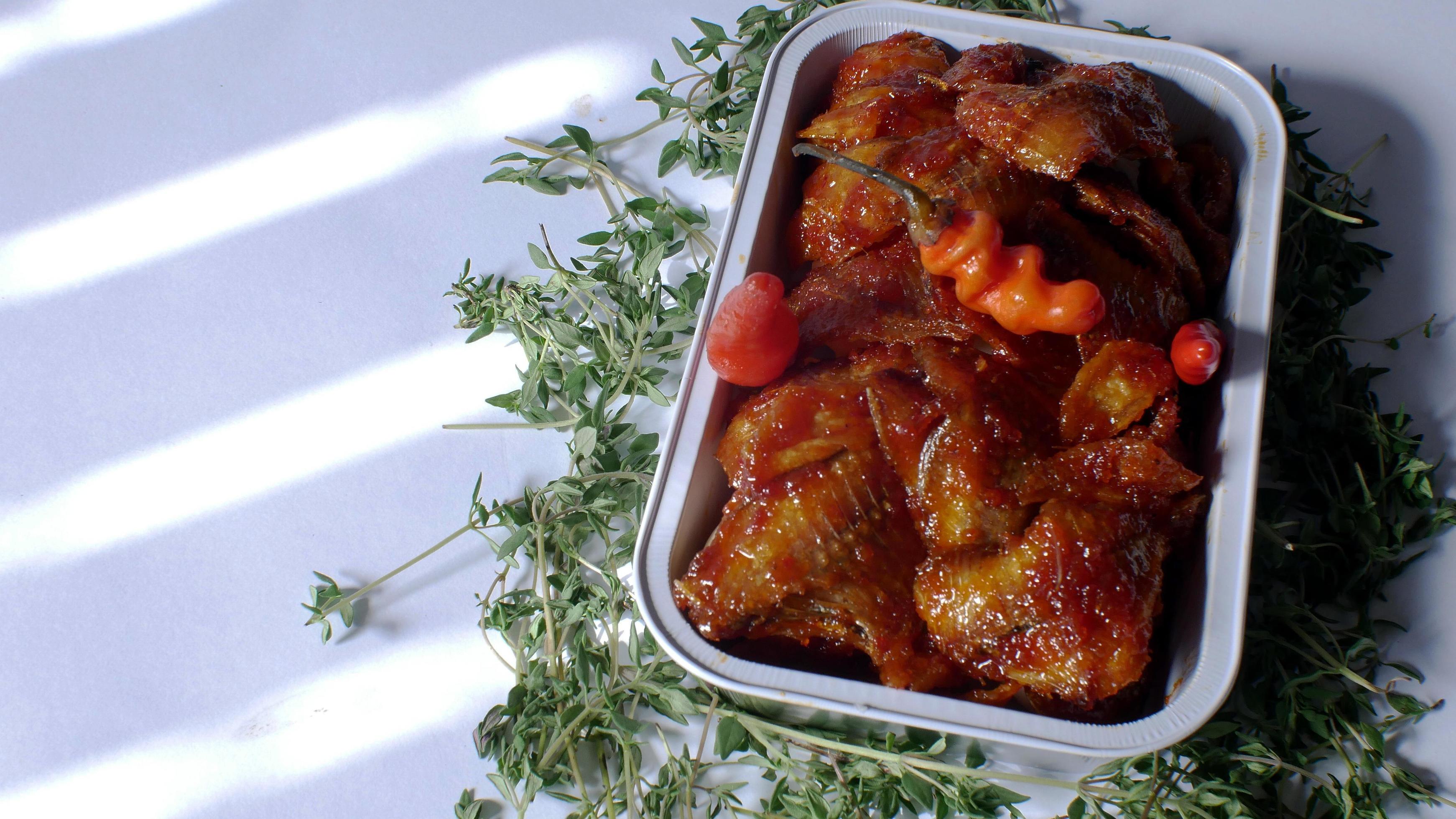 salted fish with spicy sweet and sour seasoning Indonesian food served simply in an aluminum place with white background Stock Free