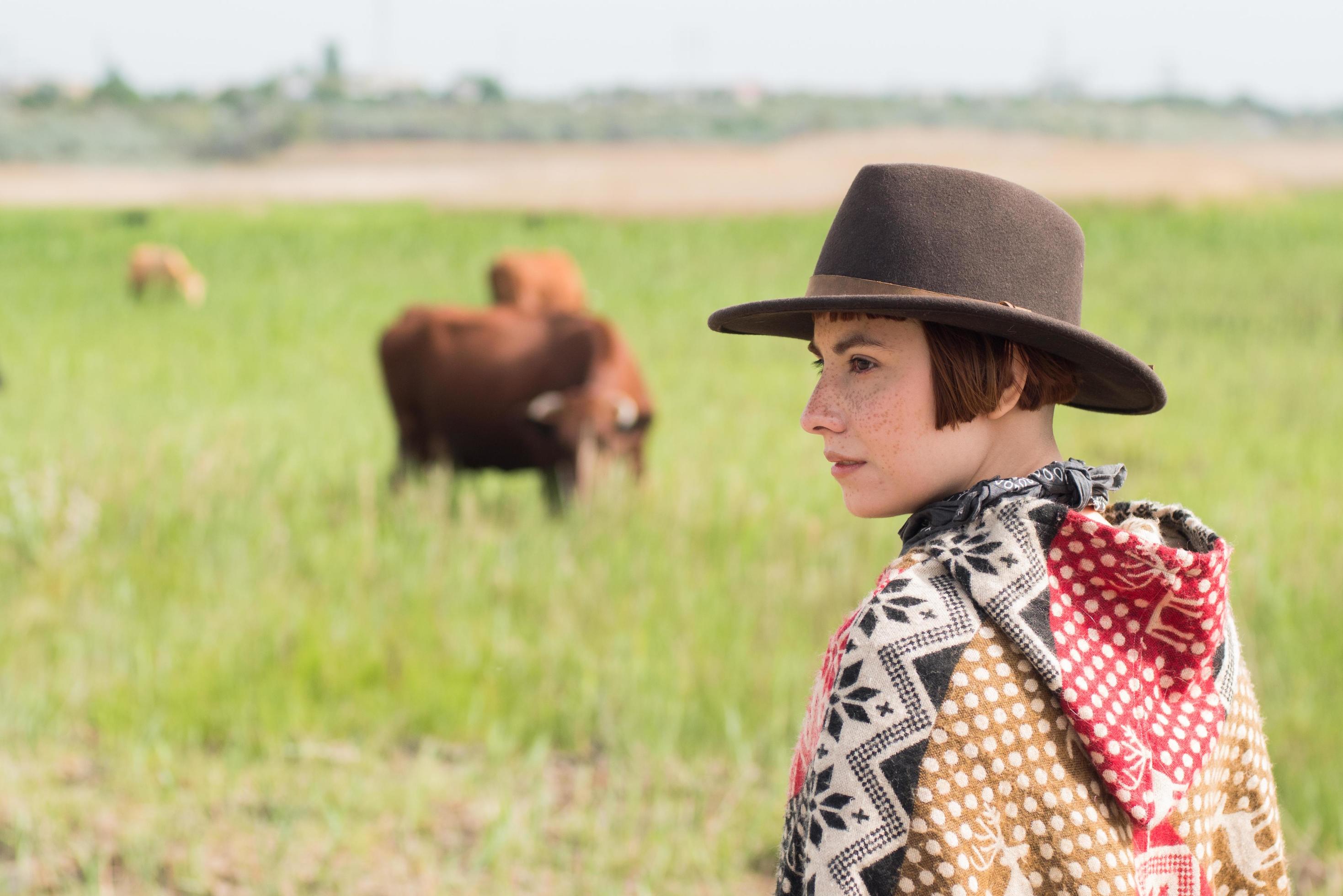 Young woman traveler in poncho and hat walk in the fields and farm Stock Free