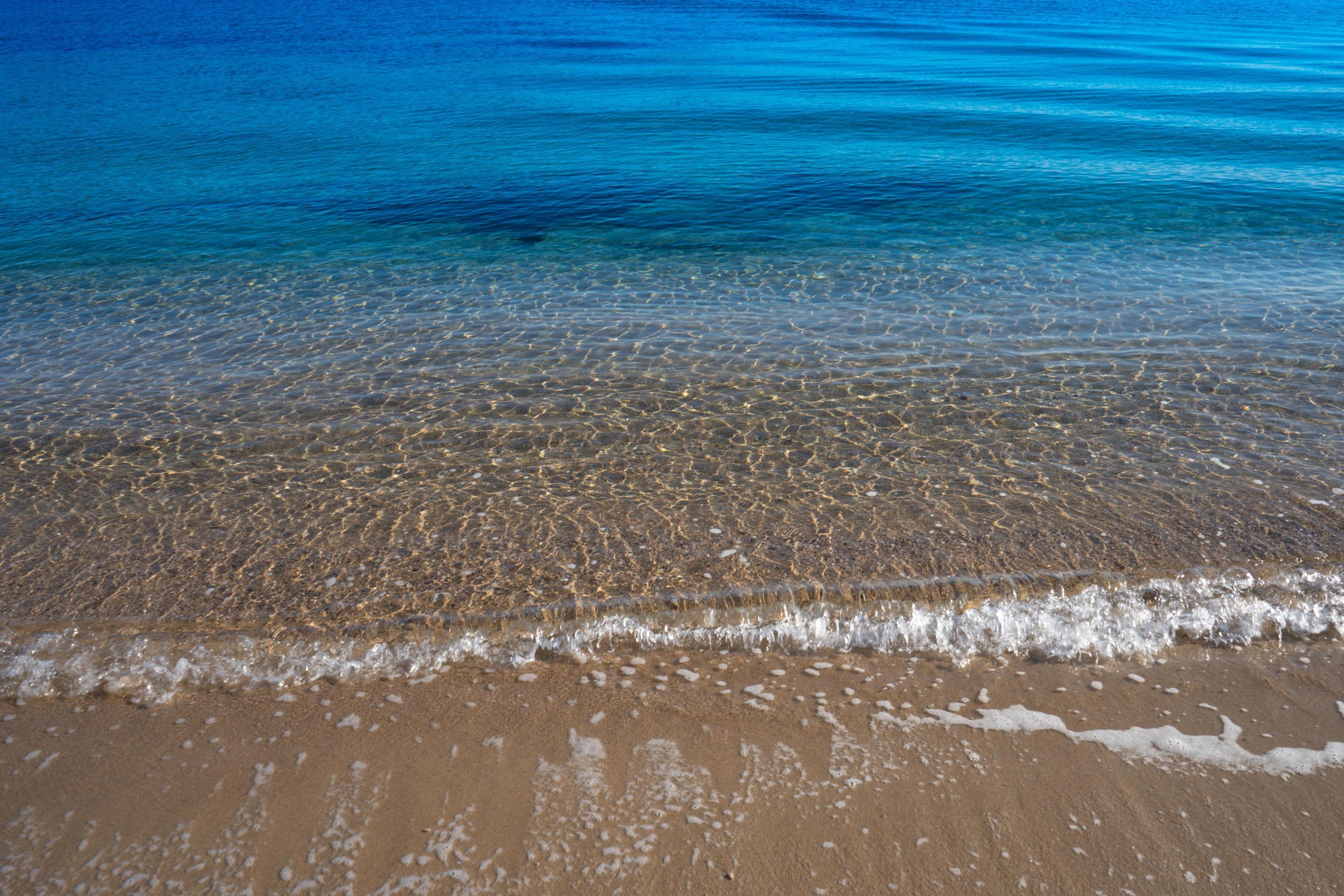 Natural background with water surface and sandy beach Stock Free