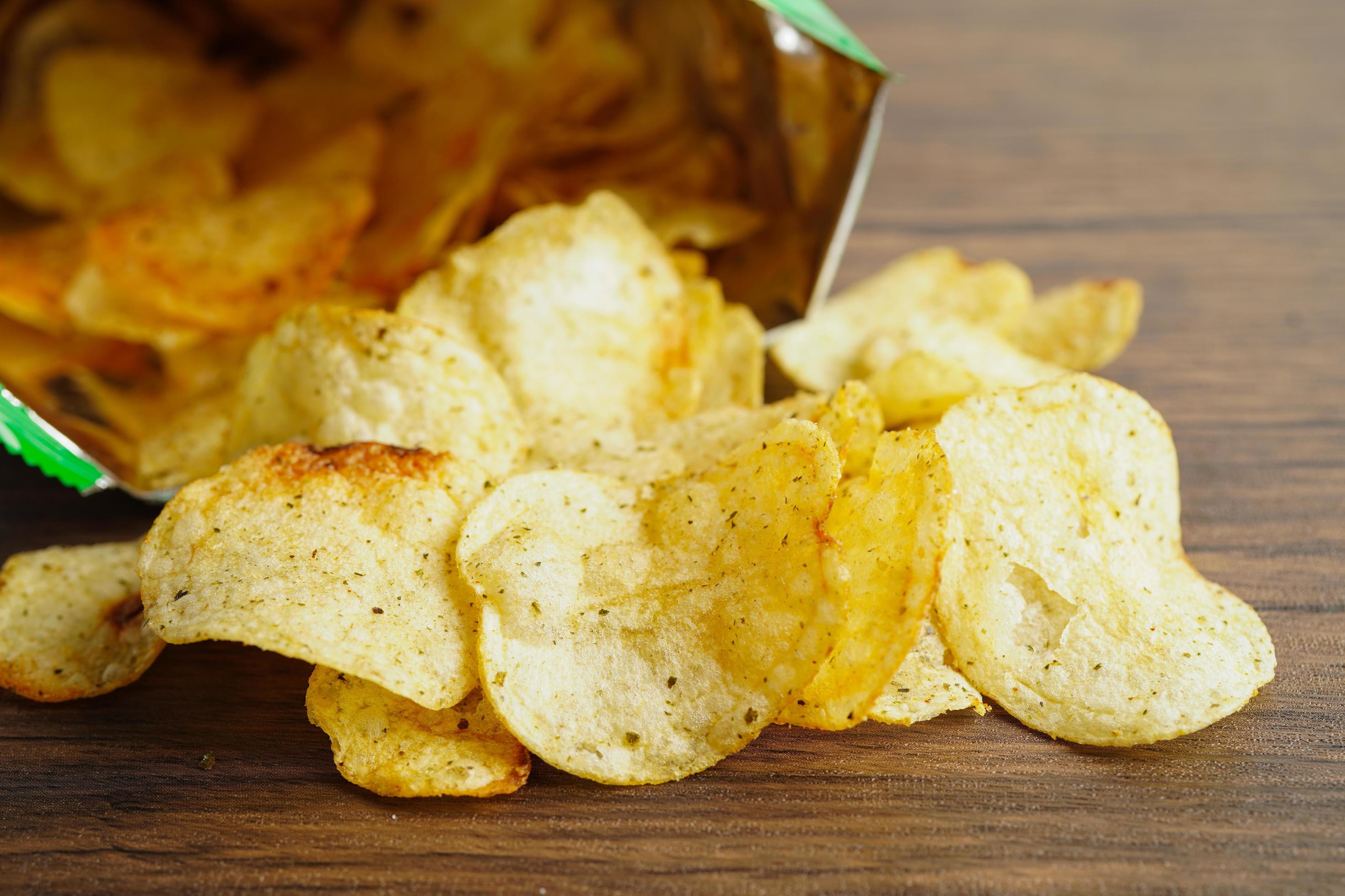 Potato chips in open bag, delicious BBQ seasoning spicy for crips, thin slice deep fried snack fast food in open bag. Stock Free