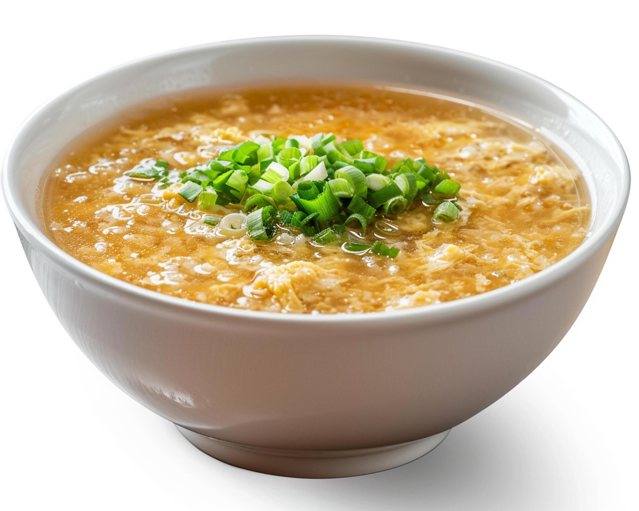 a bowl of soup with green onions in it Stock Free