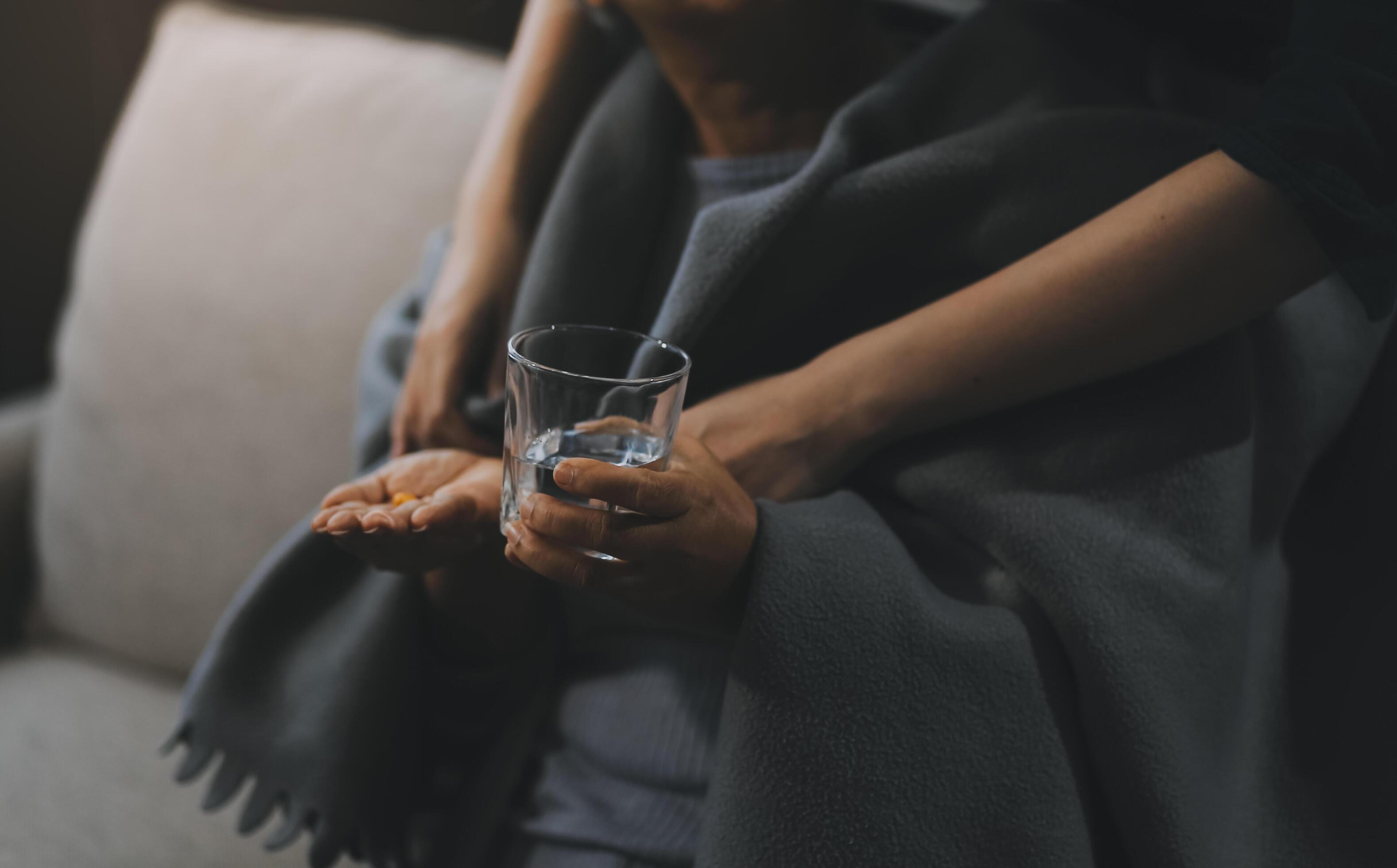 happy family Granddaughter takes care of her grandmother with warm cloths sitting on the sofa. Stock Free