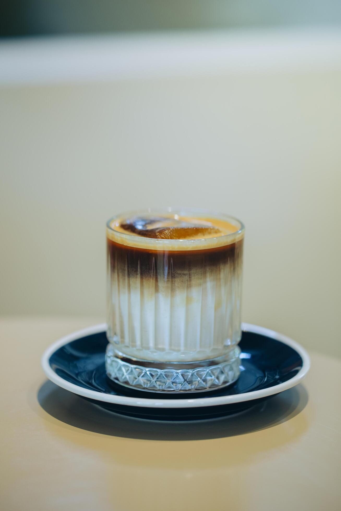 Elegant layered coffee in a clear glass, highlighting rich textures. Stock Free