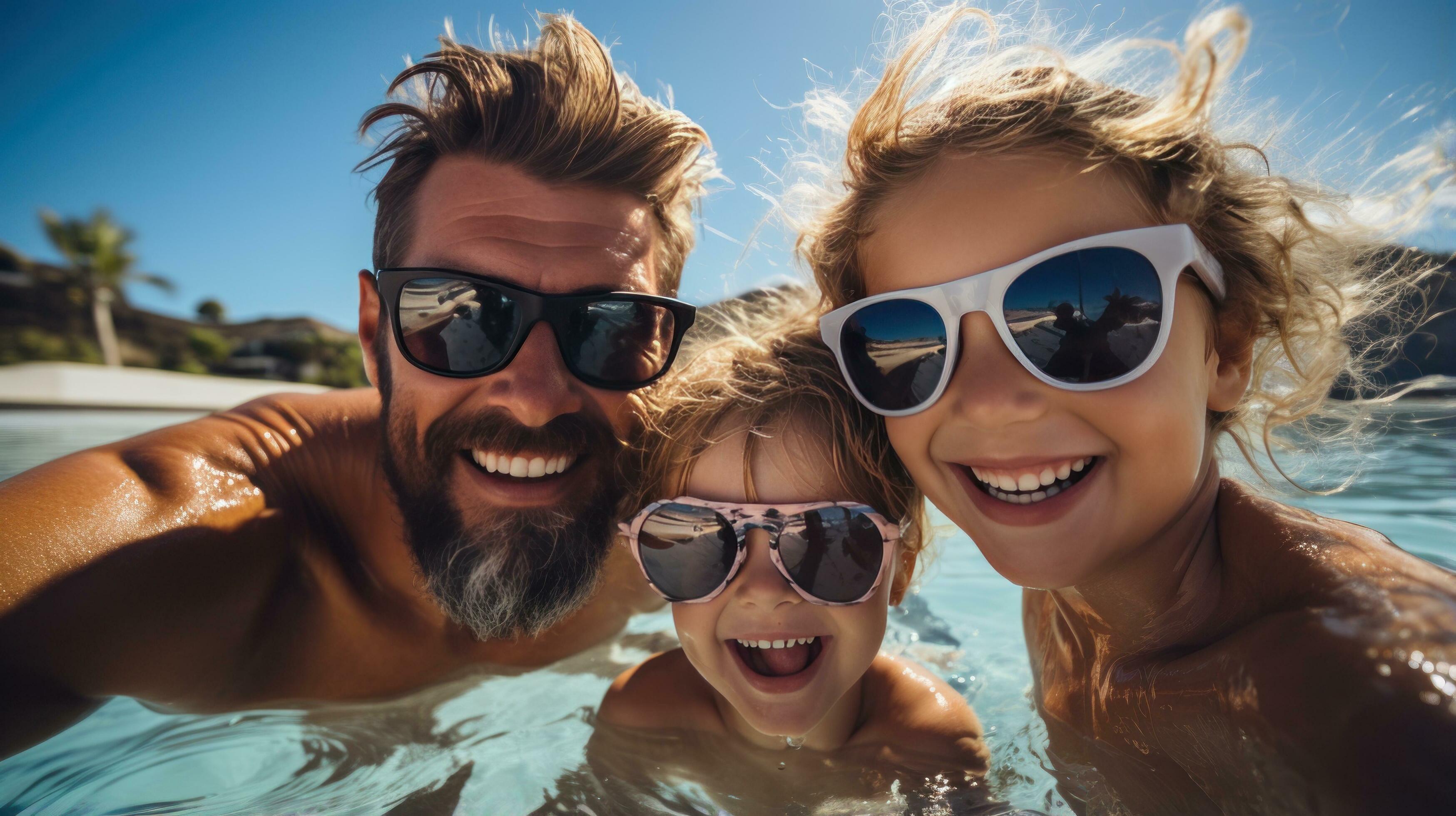 Happy family having fun in the pool on a sunny day Stock Free