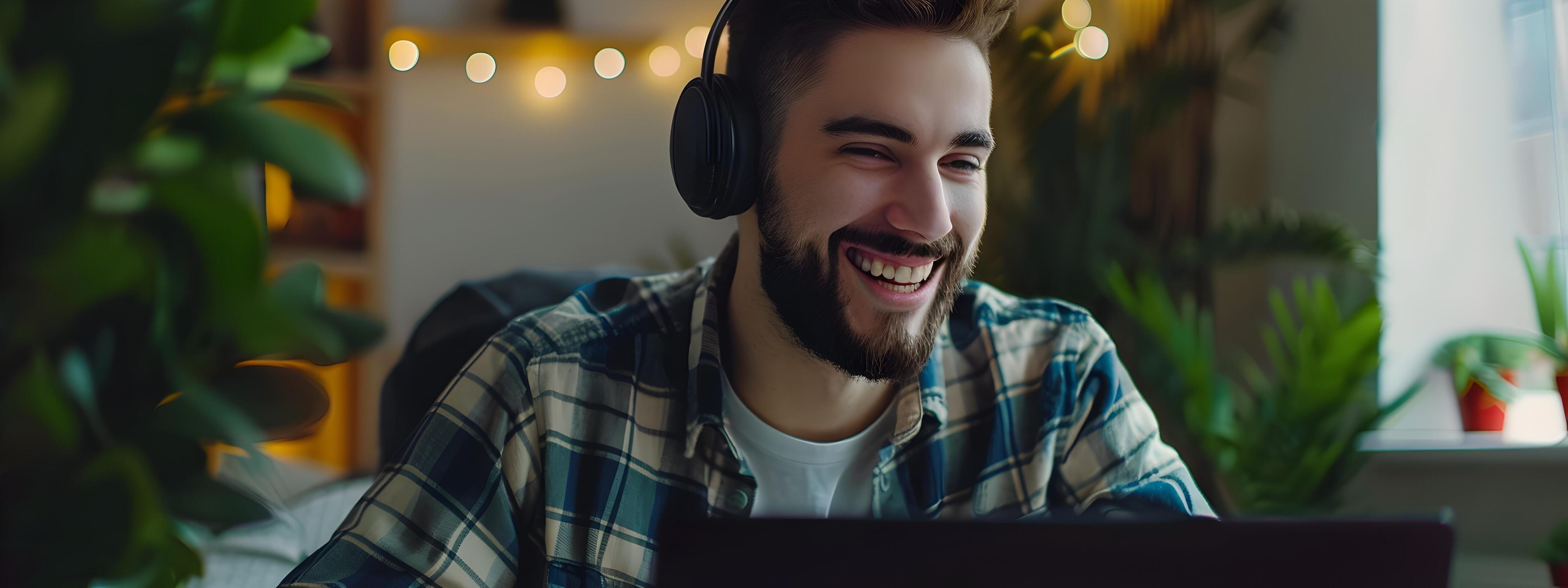 Cheerful Technical Specialist Happily Working on Laptop in Cozy Home Office Stock Free