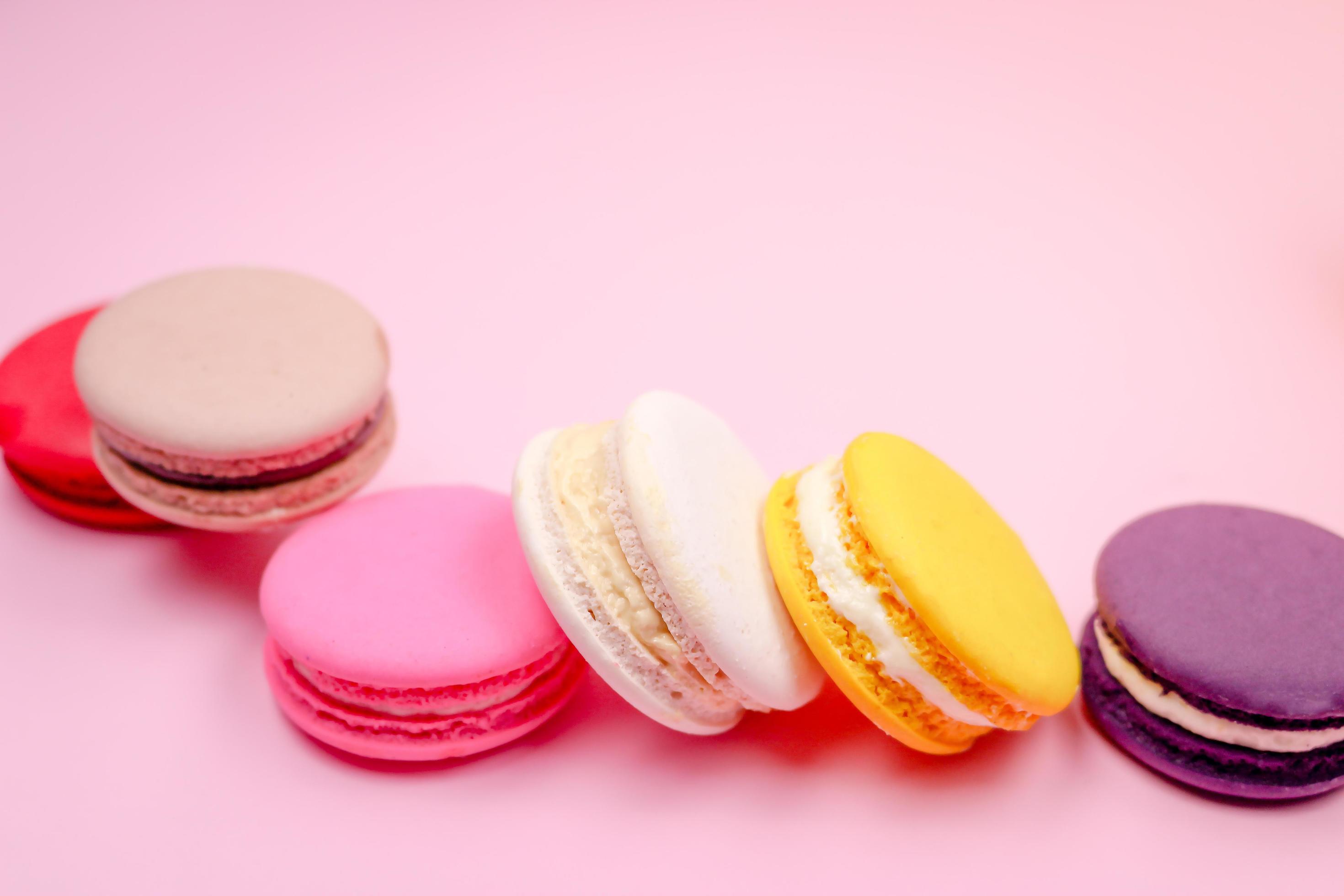 Colorful french macarons macaroons cake, delicious sweet dessert on a pink background with copyspace, food background concept. Stock Free