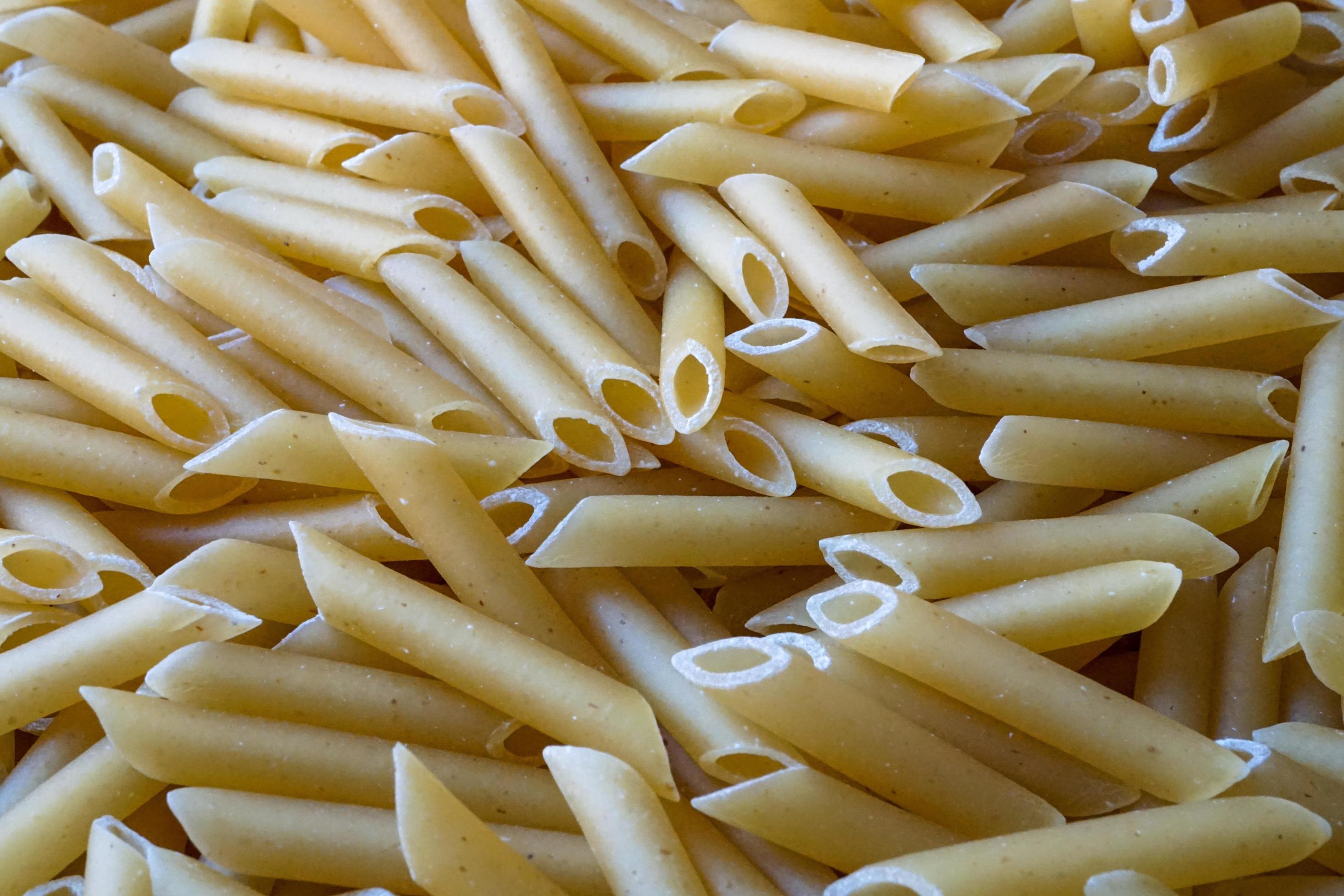 uncooked macaroni pasta background, italian food Stock Free