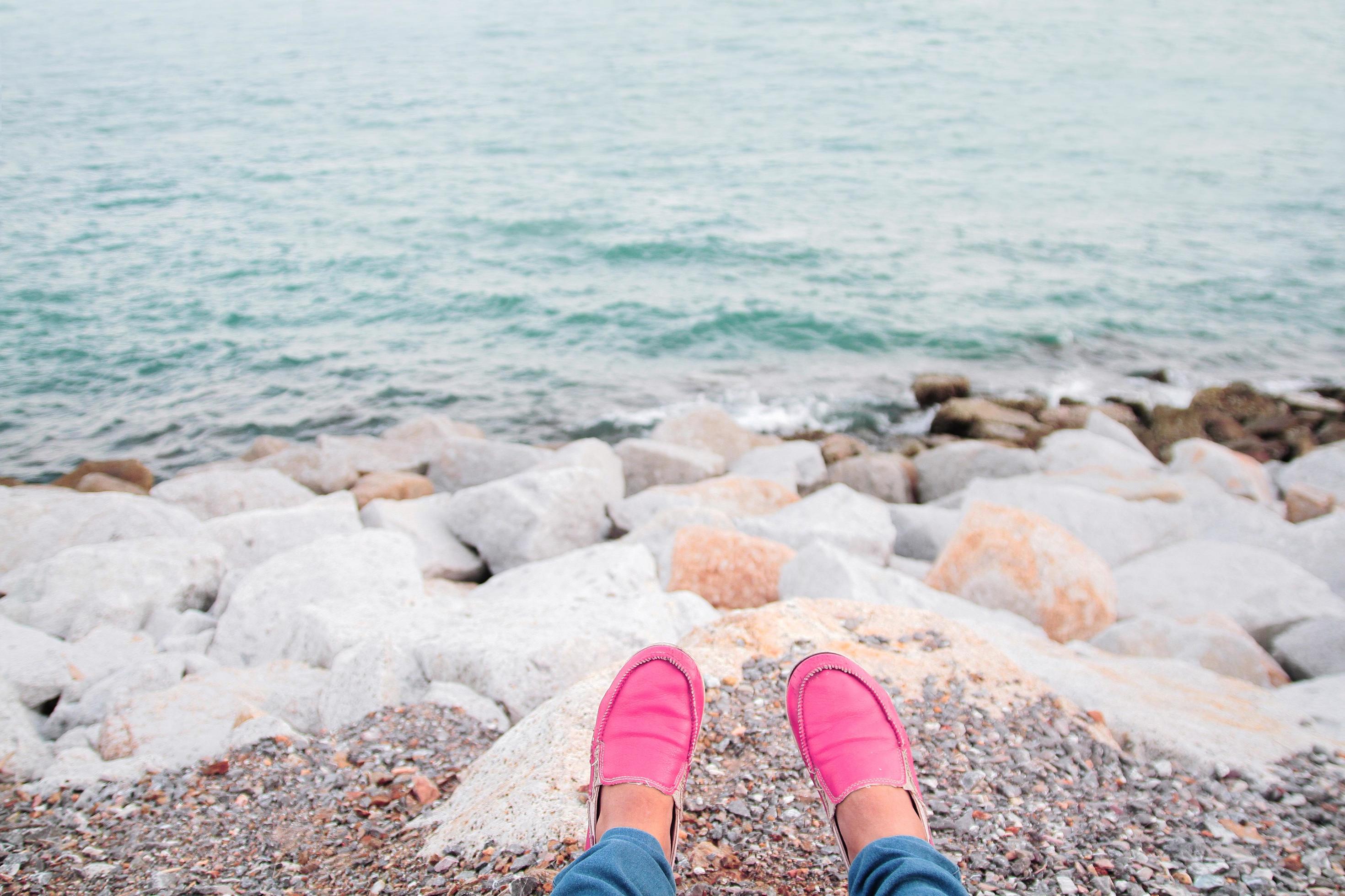 Women wearing pink shoes Sit and relax on the beach in Summer time. Stock Free