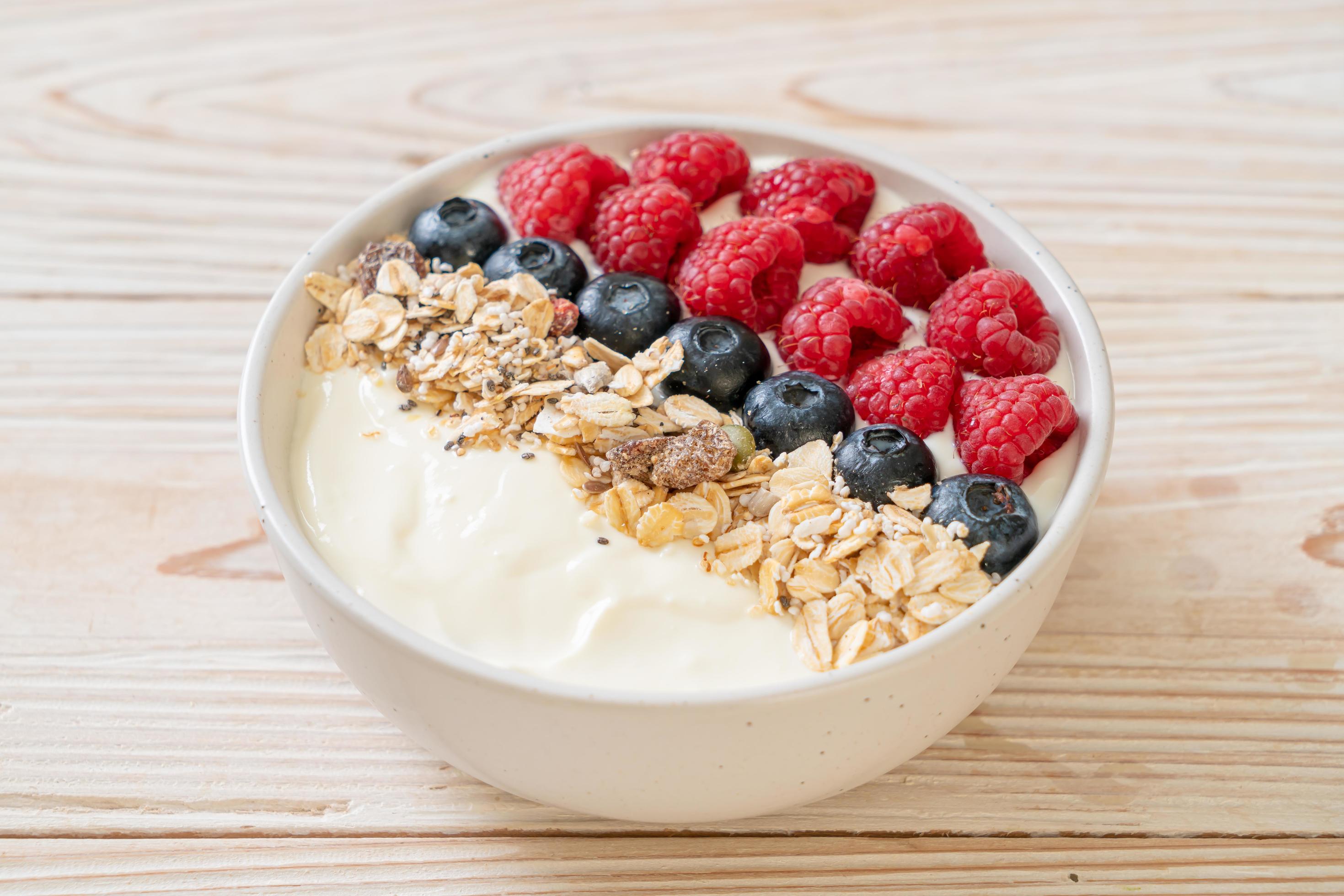 Homemade yogurt bowl with raspberry, blueberry and granola – healthy food style Stock Free