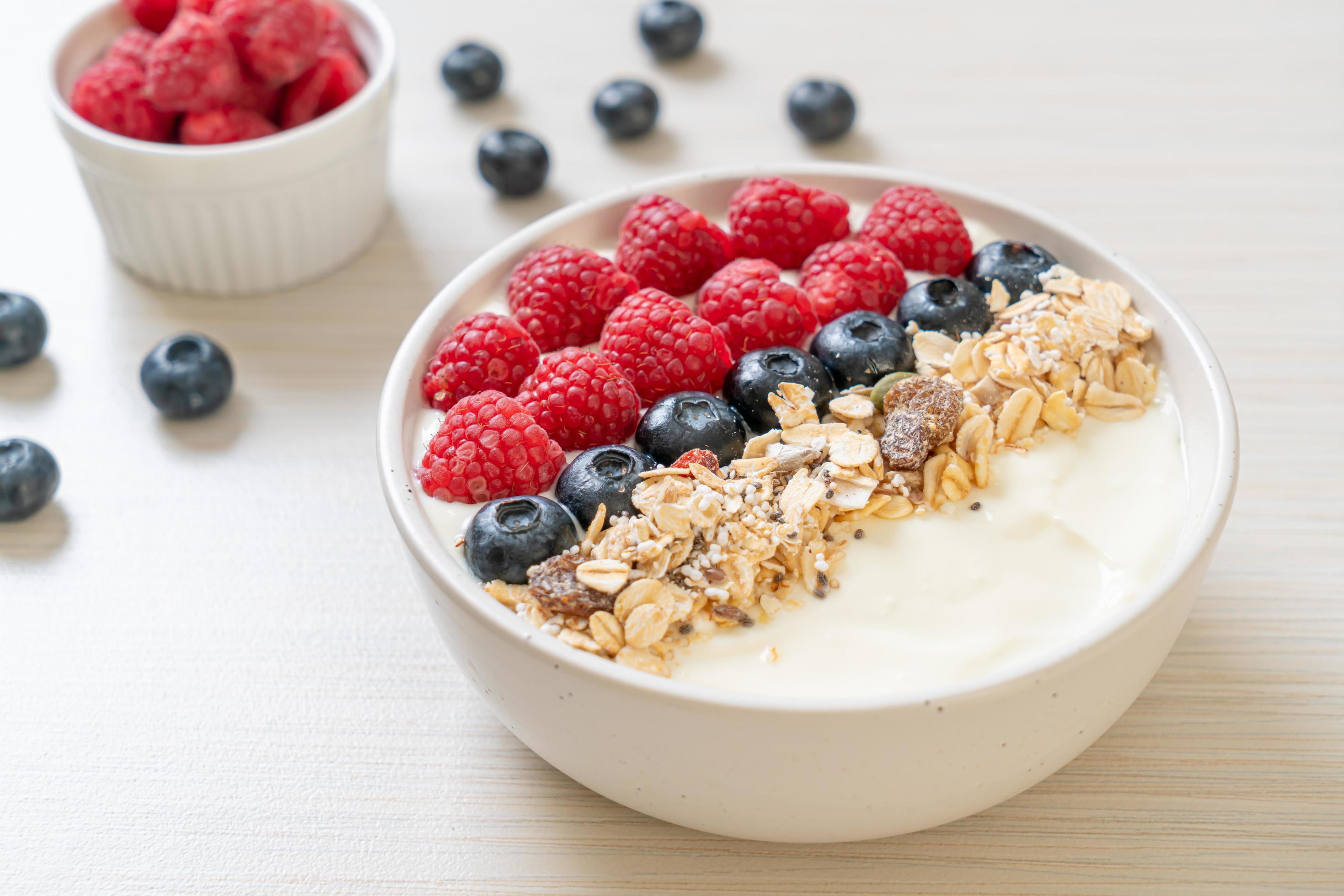 Homemade yogurt bowl with raspberry, blueberry and granola – healthy food style Stock Free