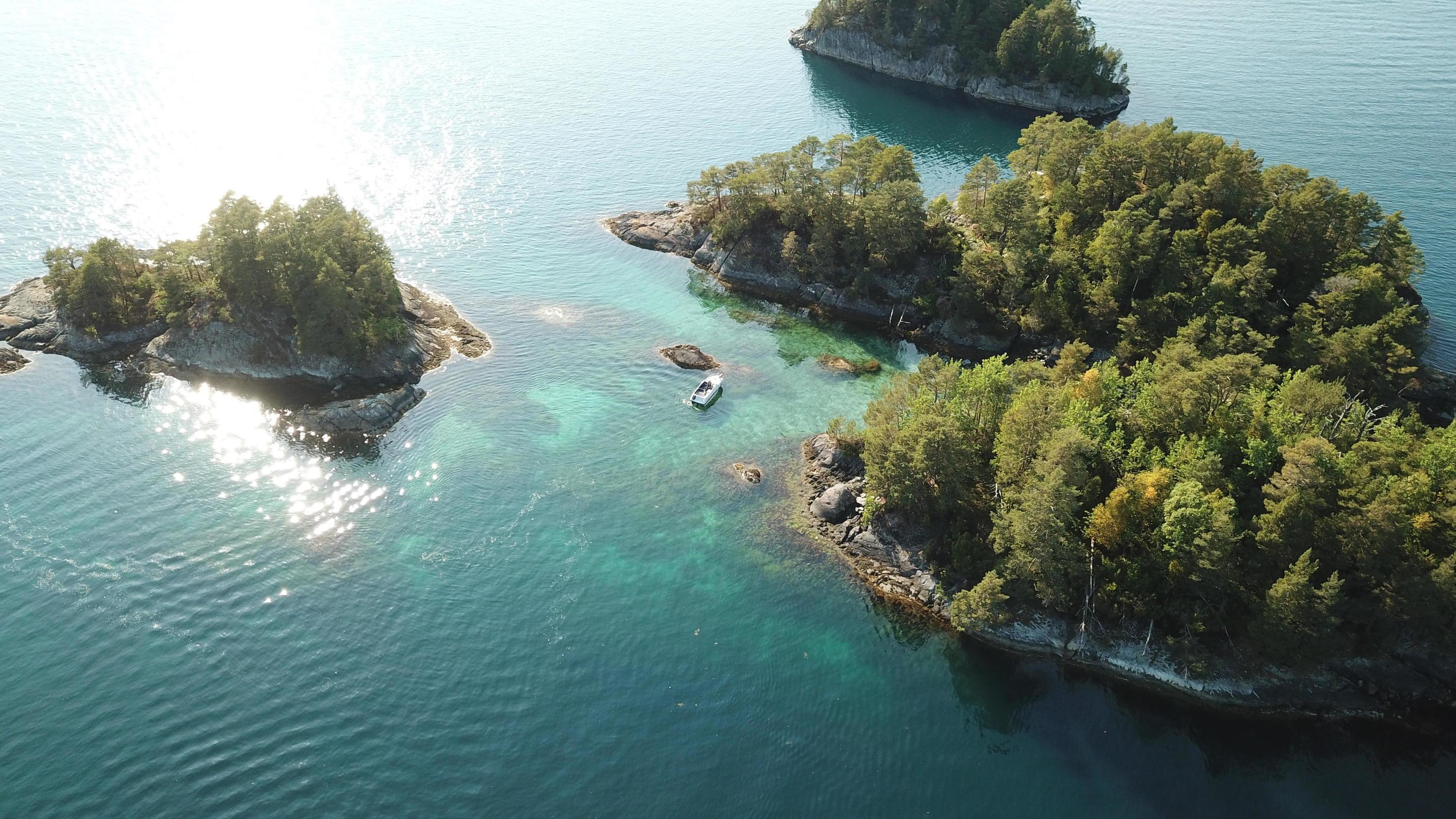 Aerial view of a boat in the middle of islands Stock Free