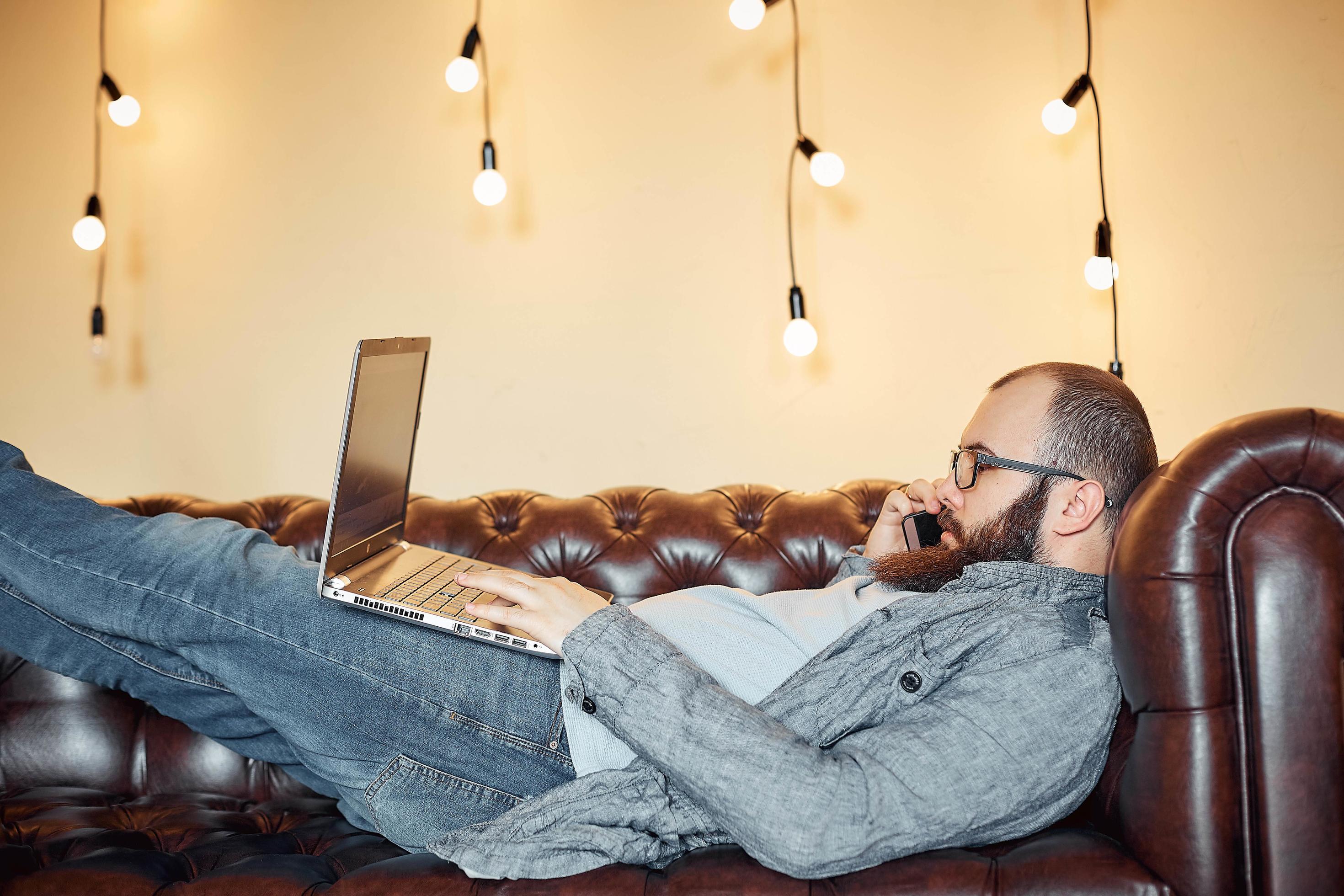 lifestyle successful freelancer man with beard achieves new goal with laptop in loft interior Stock Free