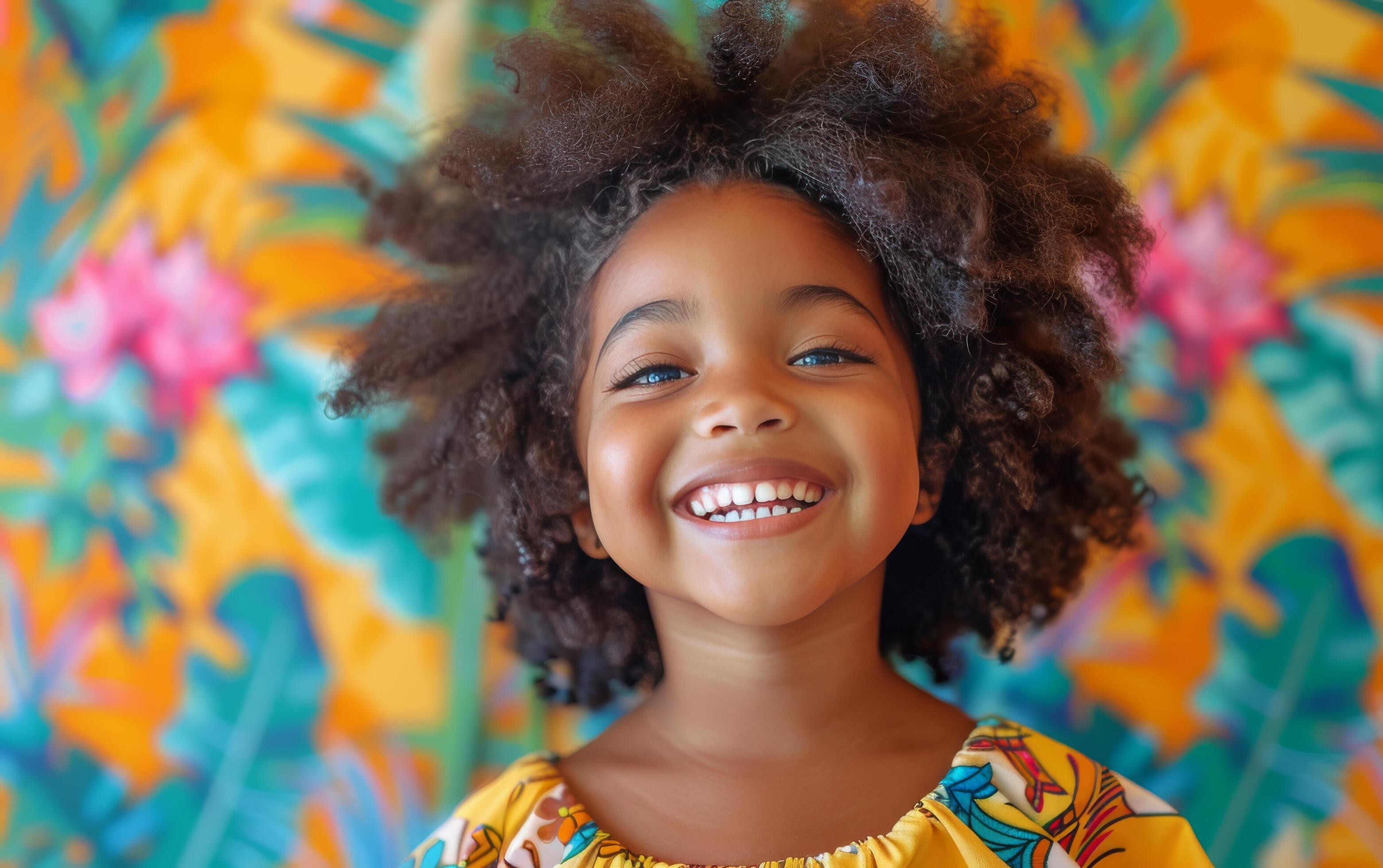 Young Girl With Curly Hair Smiles Against Colorful Floral Wall Stock Free