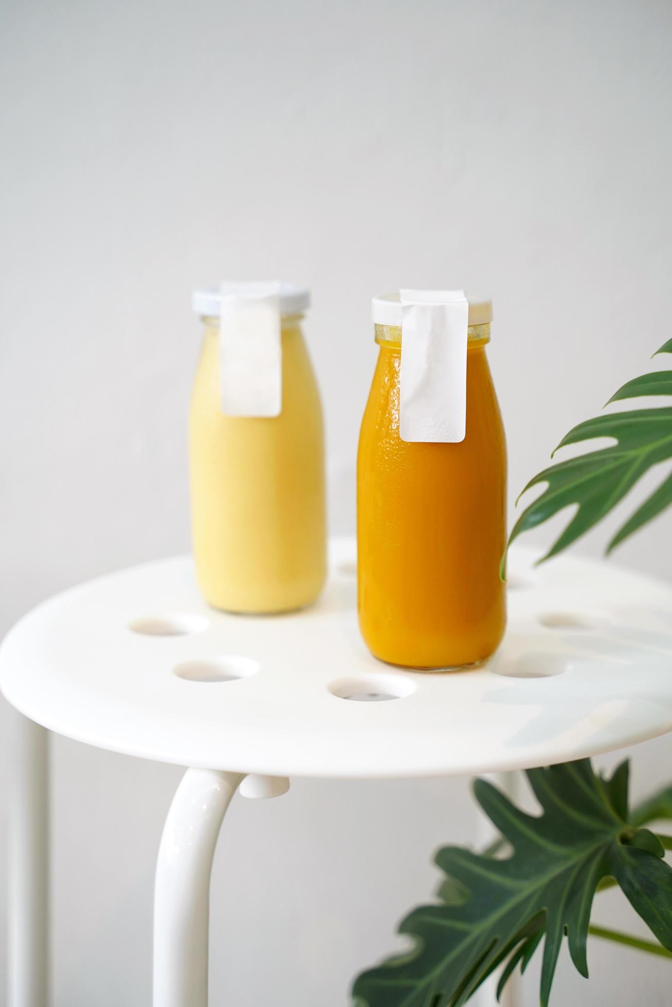 Cold pressed juice of pumpkin and pineapple in bottle mockup with blank label for healthy drink with vitamin and antioxidant, vegan lifestyle Stock Free