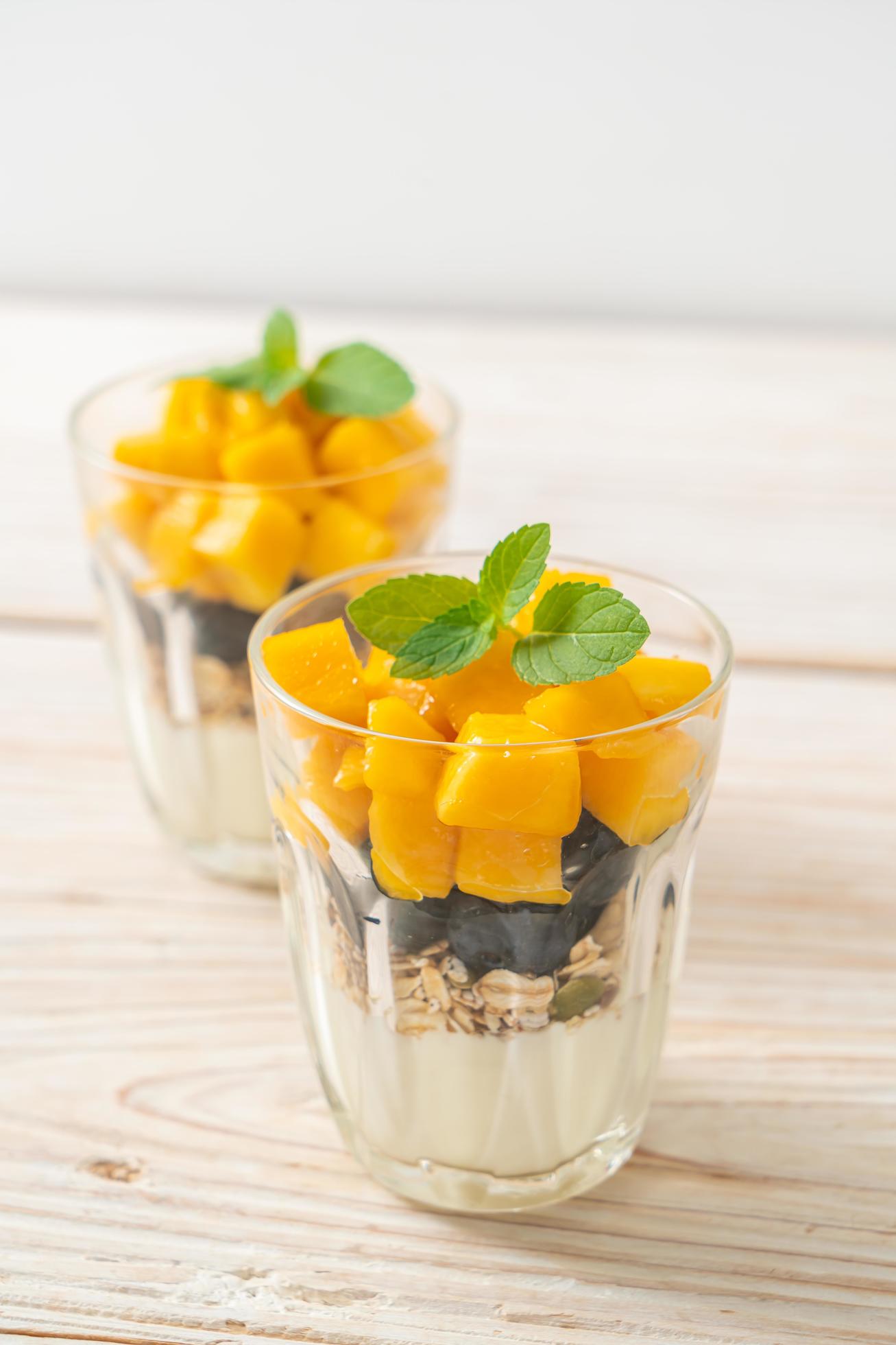 Homemade fresh mango and fresh blueberry with yogurt and granola – healthy food style Stock Free