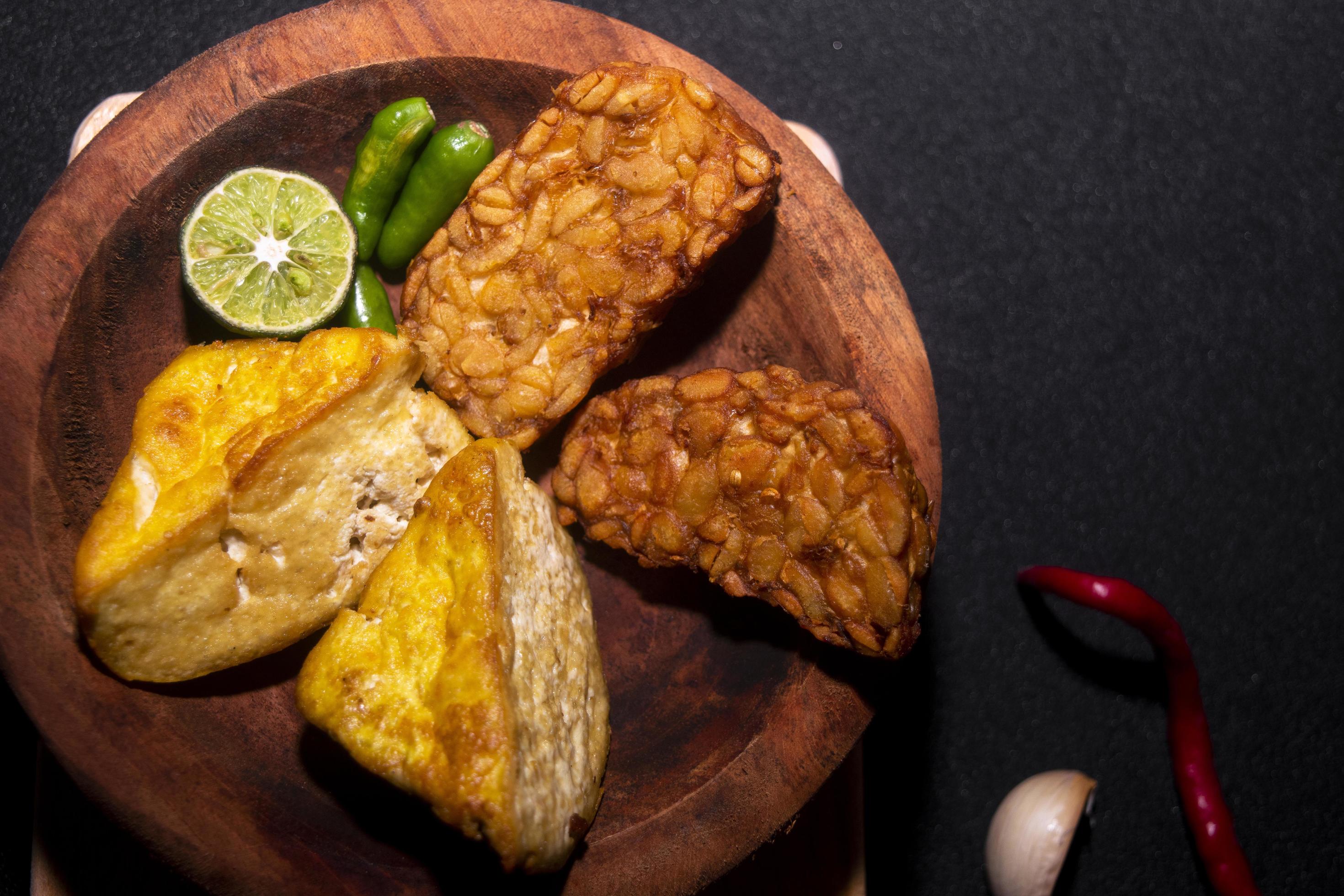 Indonesian food. tofu, tempeh, lemon, garlic and chili on black background. Stock Free