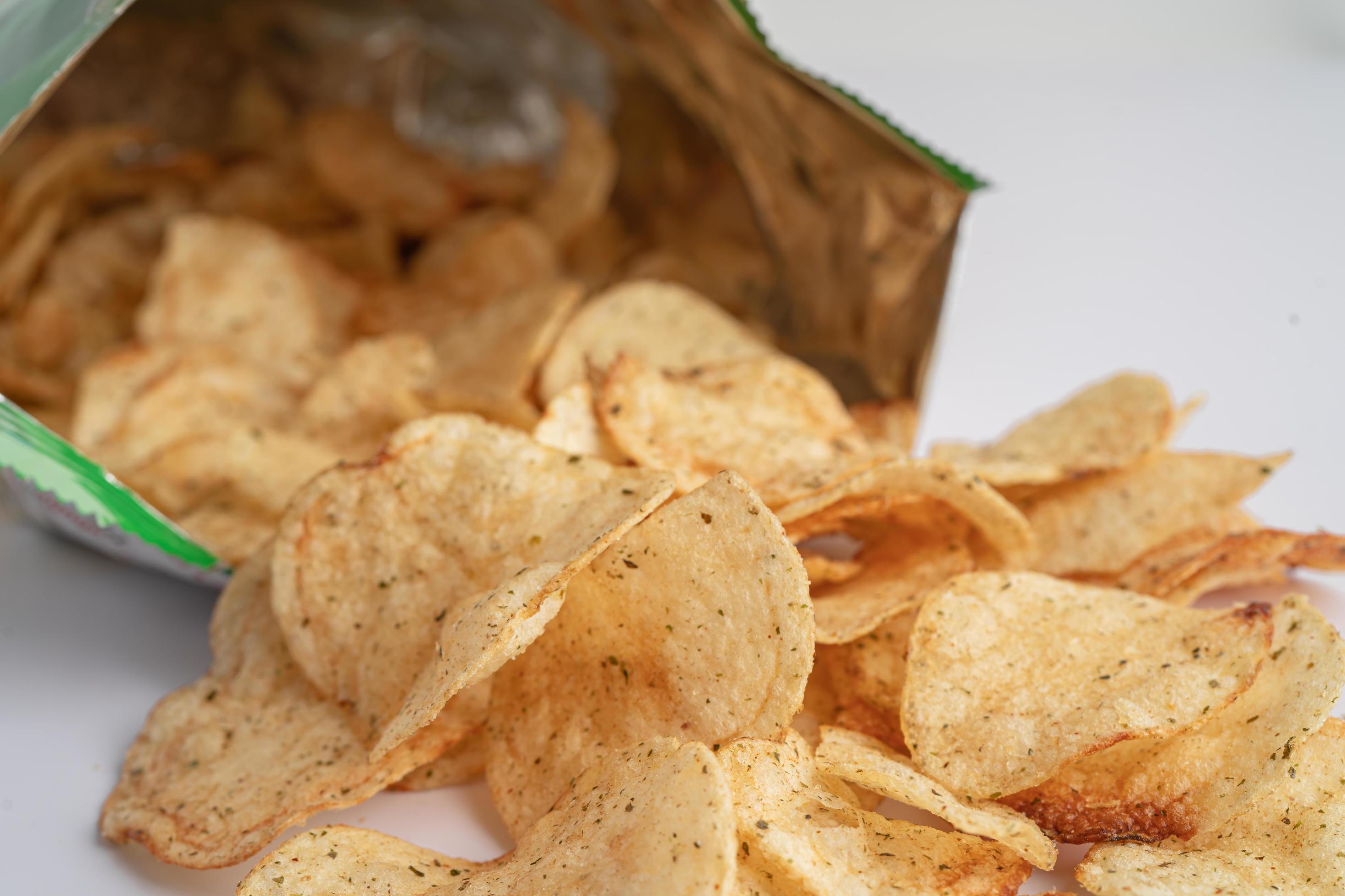 Potato chips, delicious BBQ seasoning spicy for crips, thin slice deep fried snack fast food in open bag. Stock Free