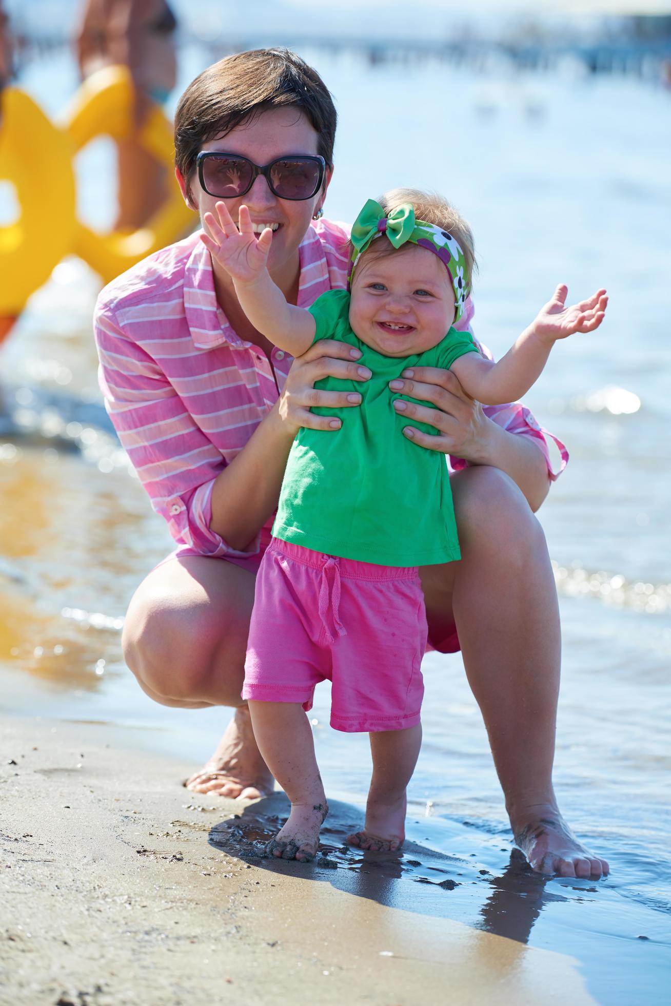 mom and baby on beach have fun Stock Free