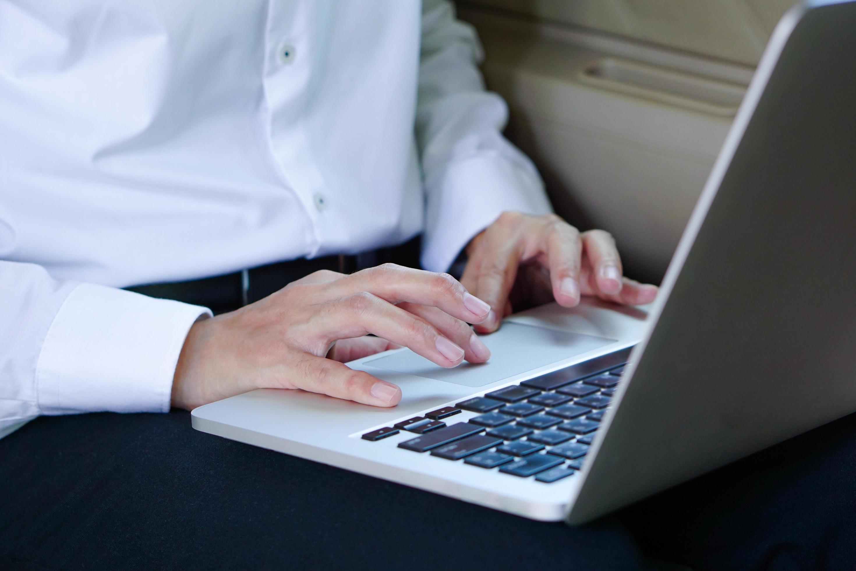 Businessman working on laptop while sitting on driver seat in car. Lifestyle concept. Stock Free