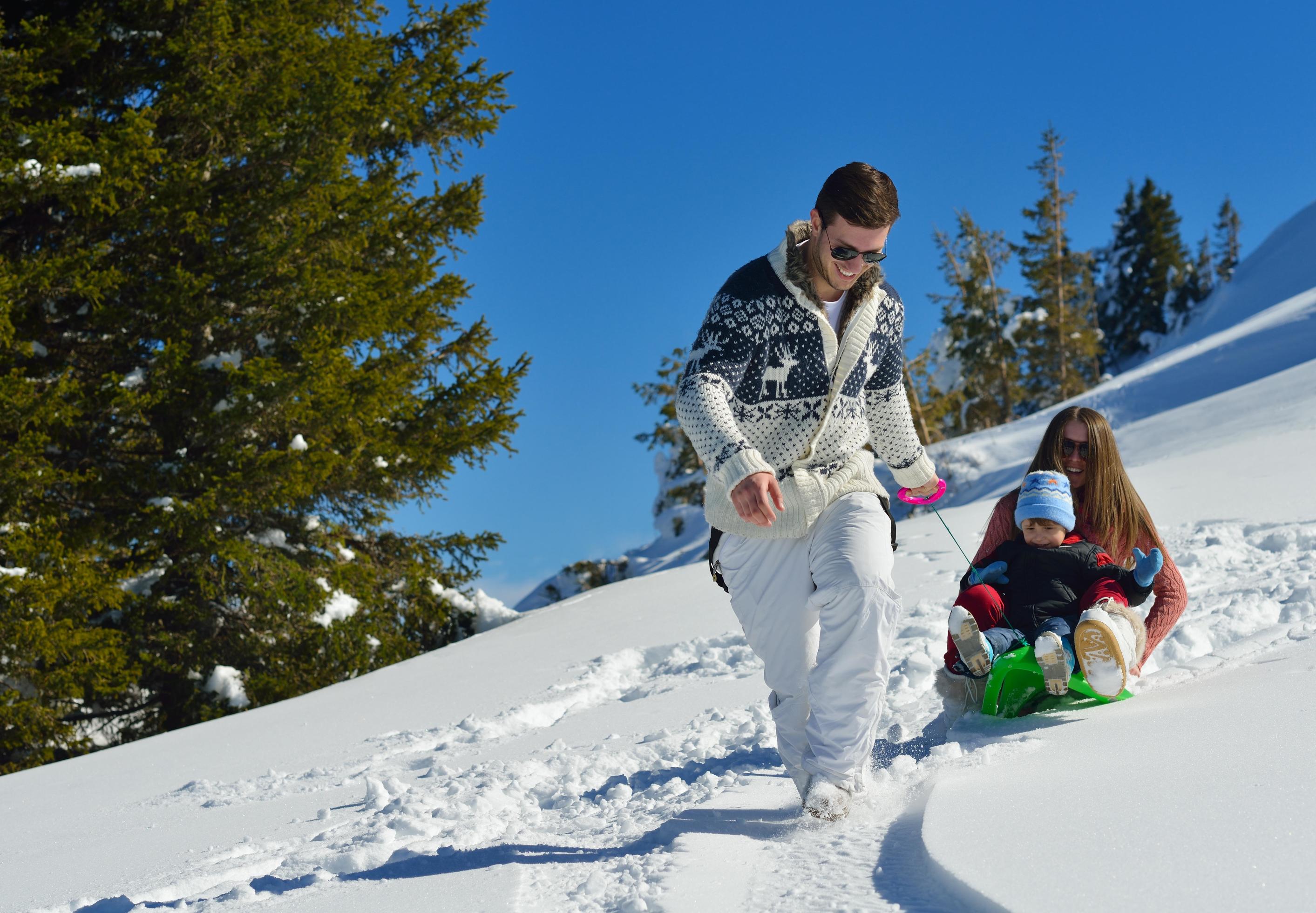 family having fun on fresh snow at winter vacation Stock Free