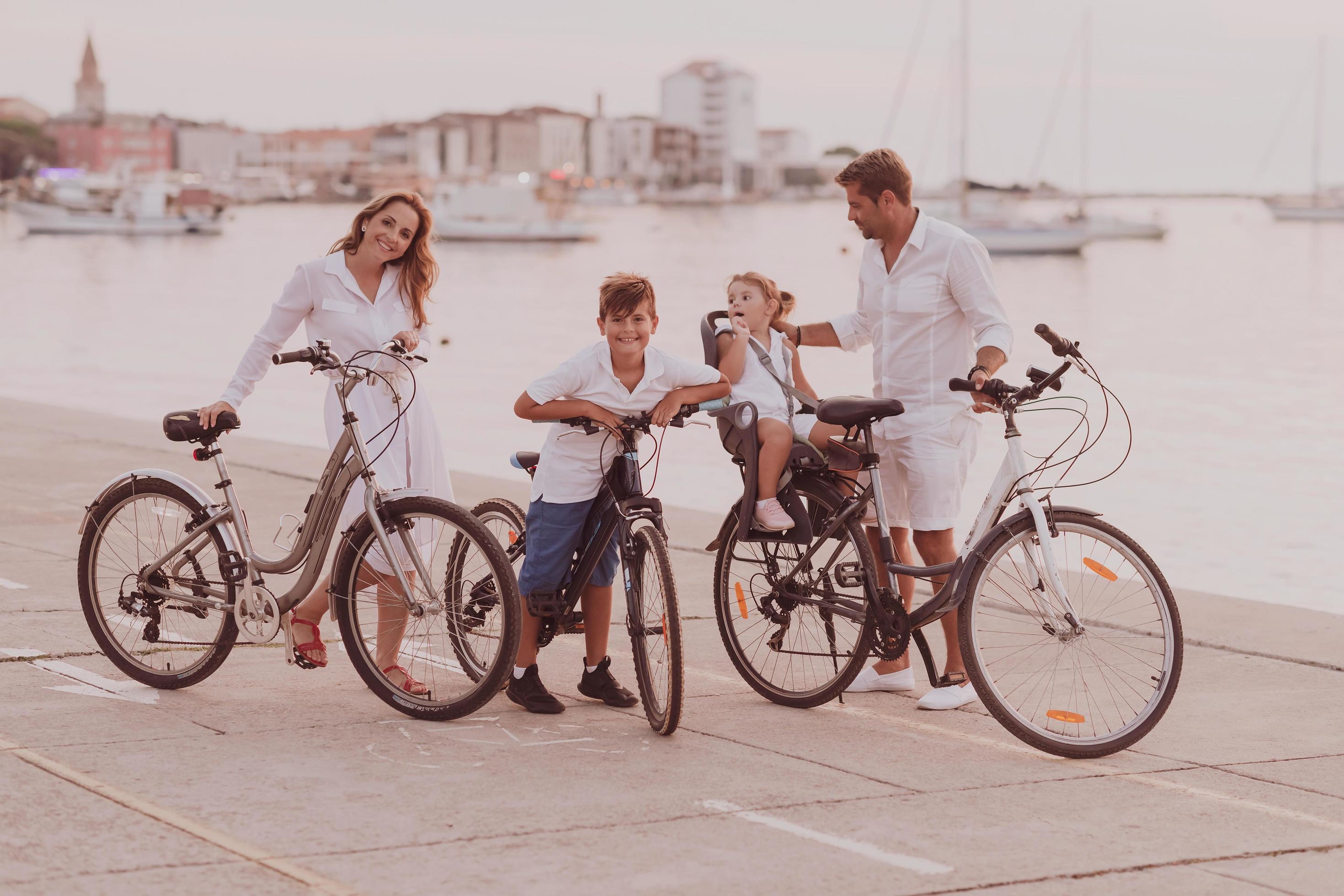 The happy family enjoys a beautiful morning by the sea riding a bike together and spending time together. The concept of a happy family Stock Free