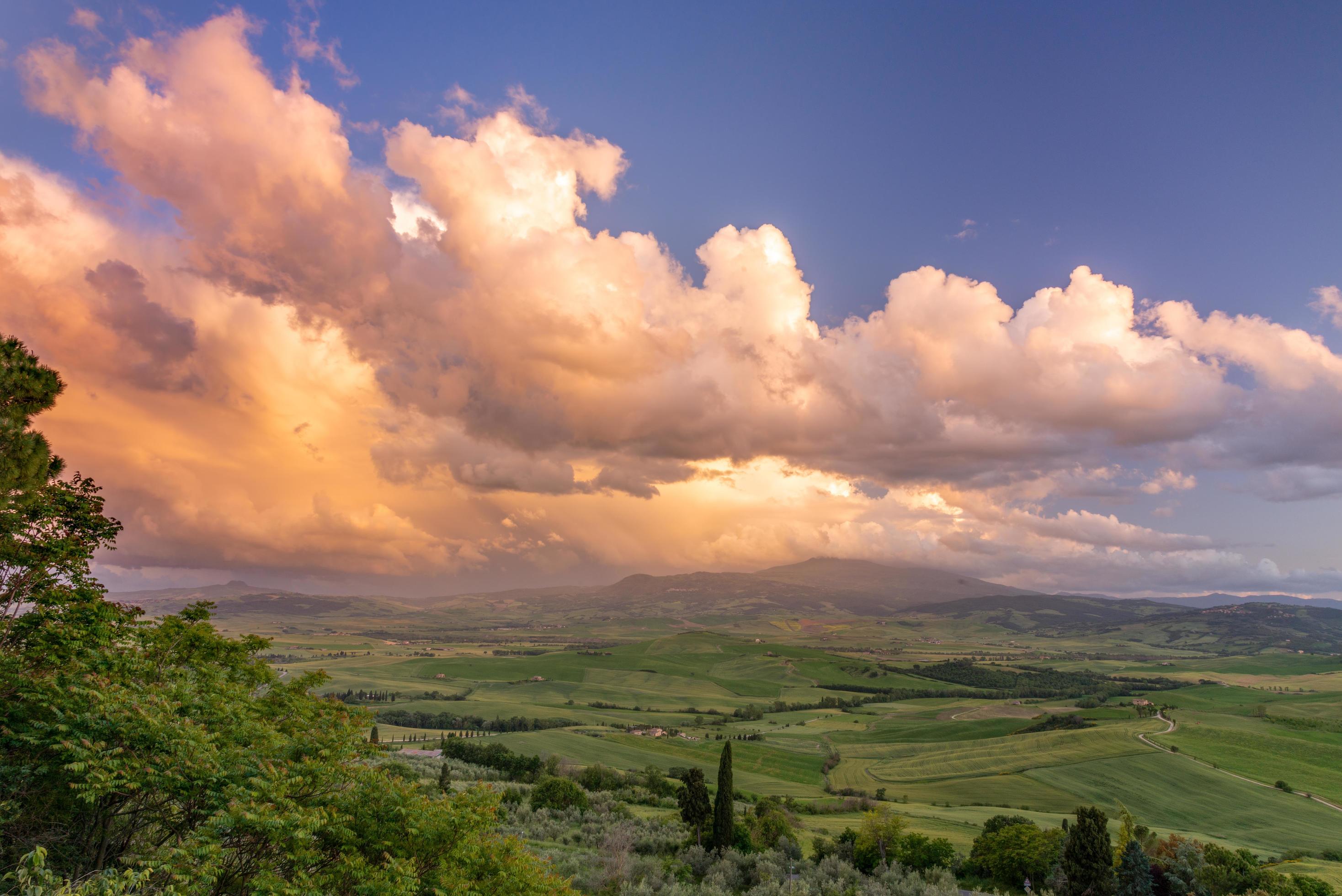 Sunset lighting up clouds over farmland near Pienza in Tuscany Stock Free