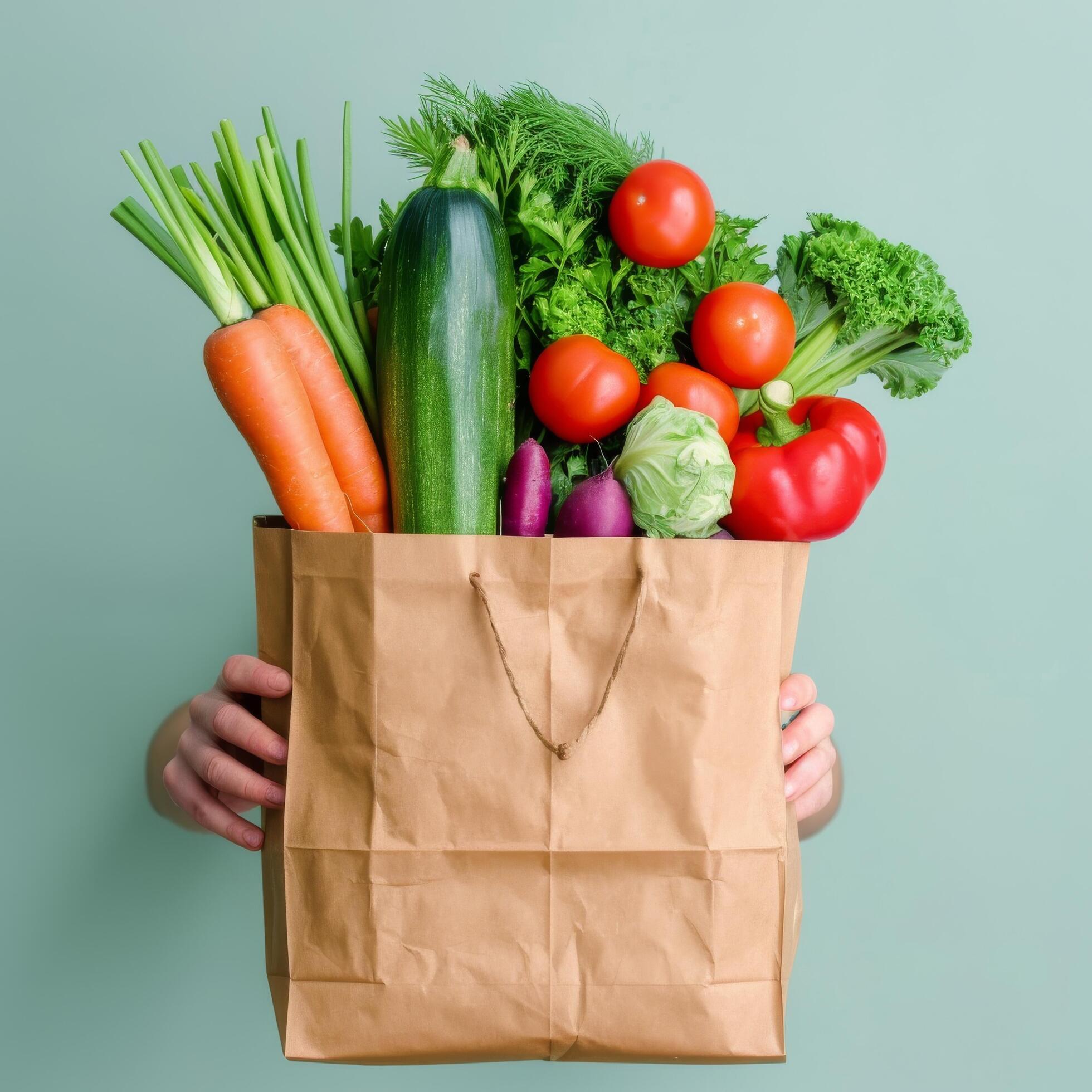 Fresh Vegetables and Greens in Brown Paper Bag Held by Person Against Light Background Stock Free