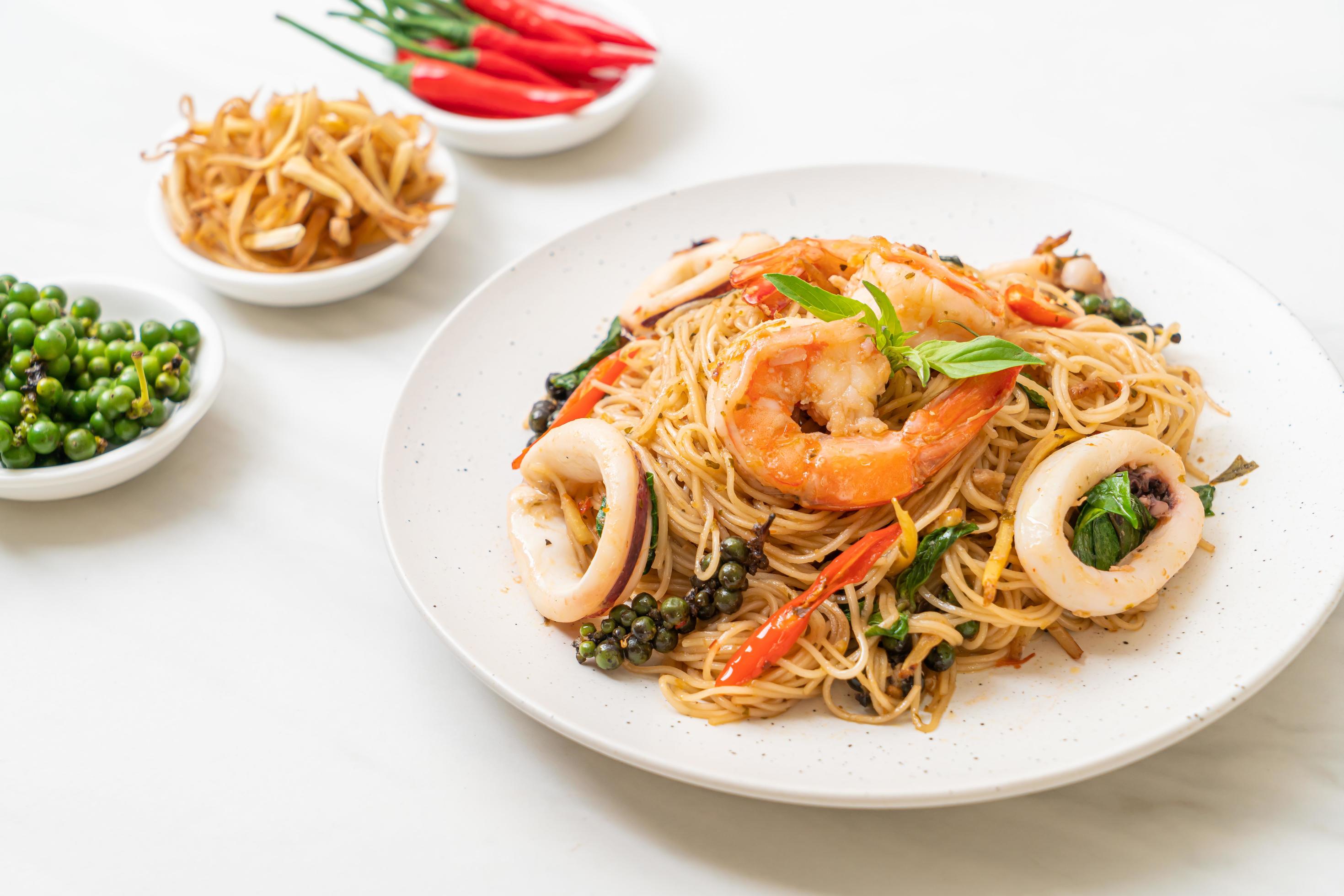 Stir-fried Chinese noodles with basil, chili, shrimp, and squid – Asian food style Stock Free