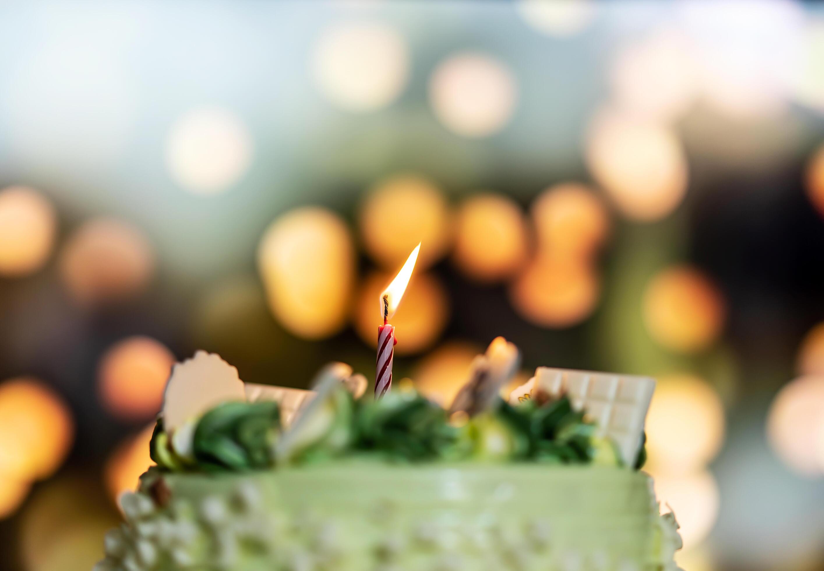 Happy birthday cake with candles on the background of bright lights bokeh. Stock Free