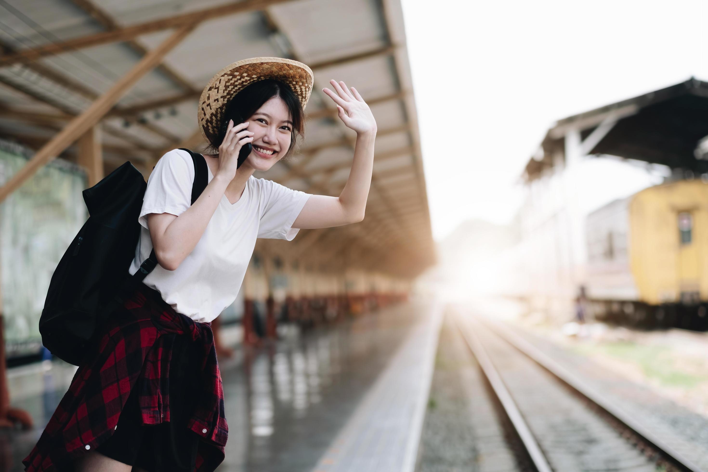 Young traveler woman looking for friend planning trip at train station. Summer and travel lifestyle concept Stock Free